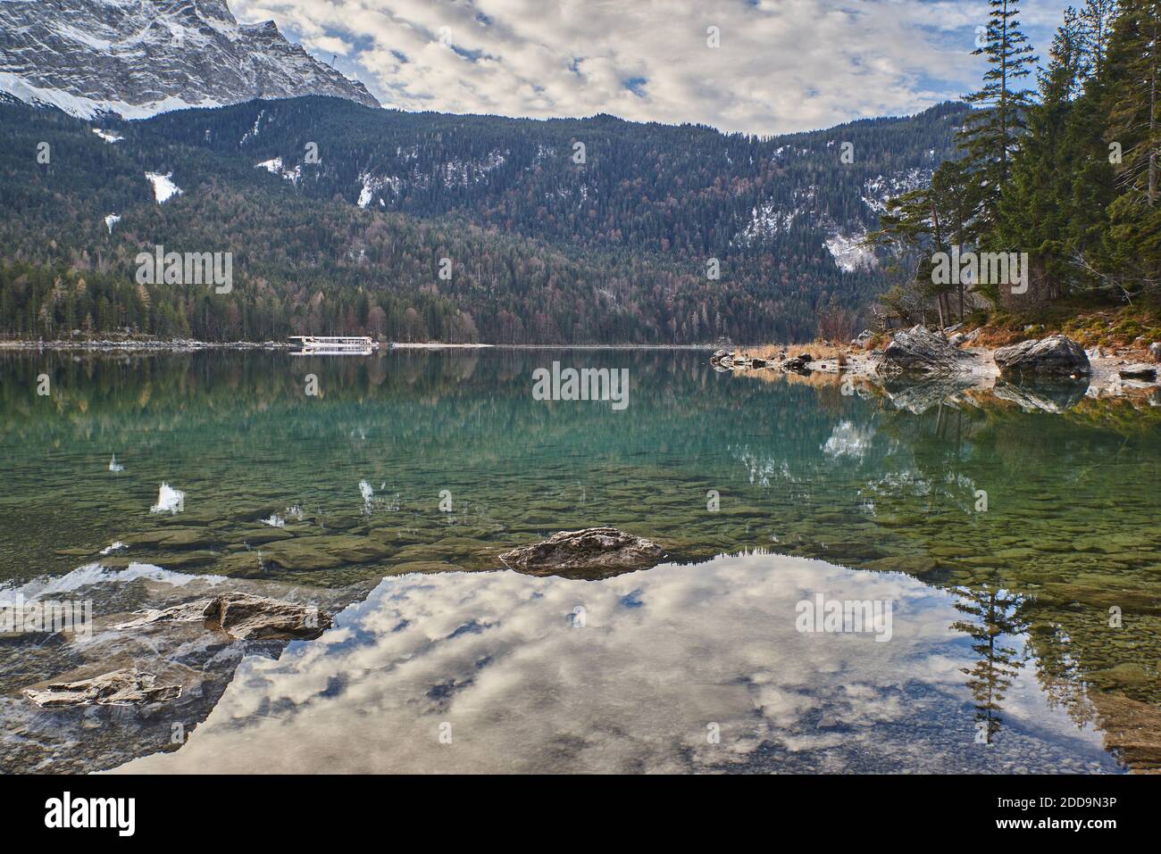 Lago di montagna riflettente nelle alpi tedesche. Eibsee in baviera. Lago di montagna turchese di fronte alle cime innevate. Foto Stock