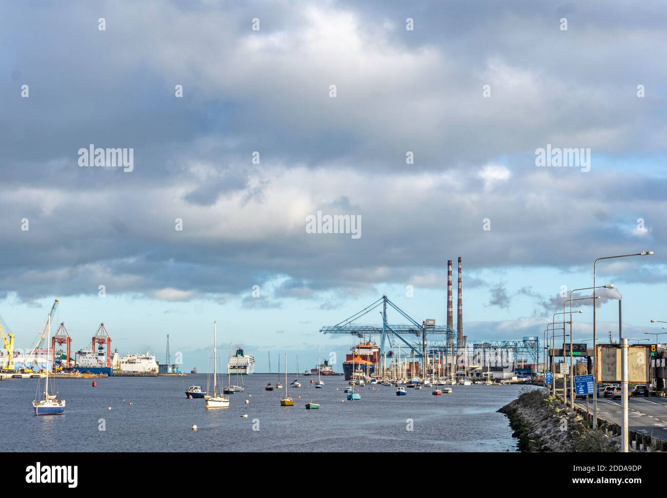 Porto di Dublino, Irlanda, con una gru a portale in funzione, un traghetto passeggeri in partenza, piccole barche e l'East link Ferry Bridge. Foto Stock