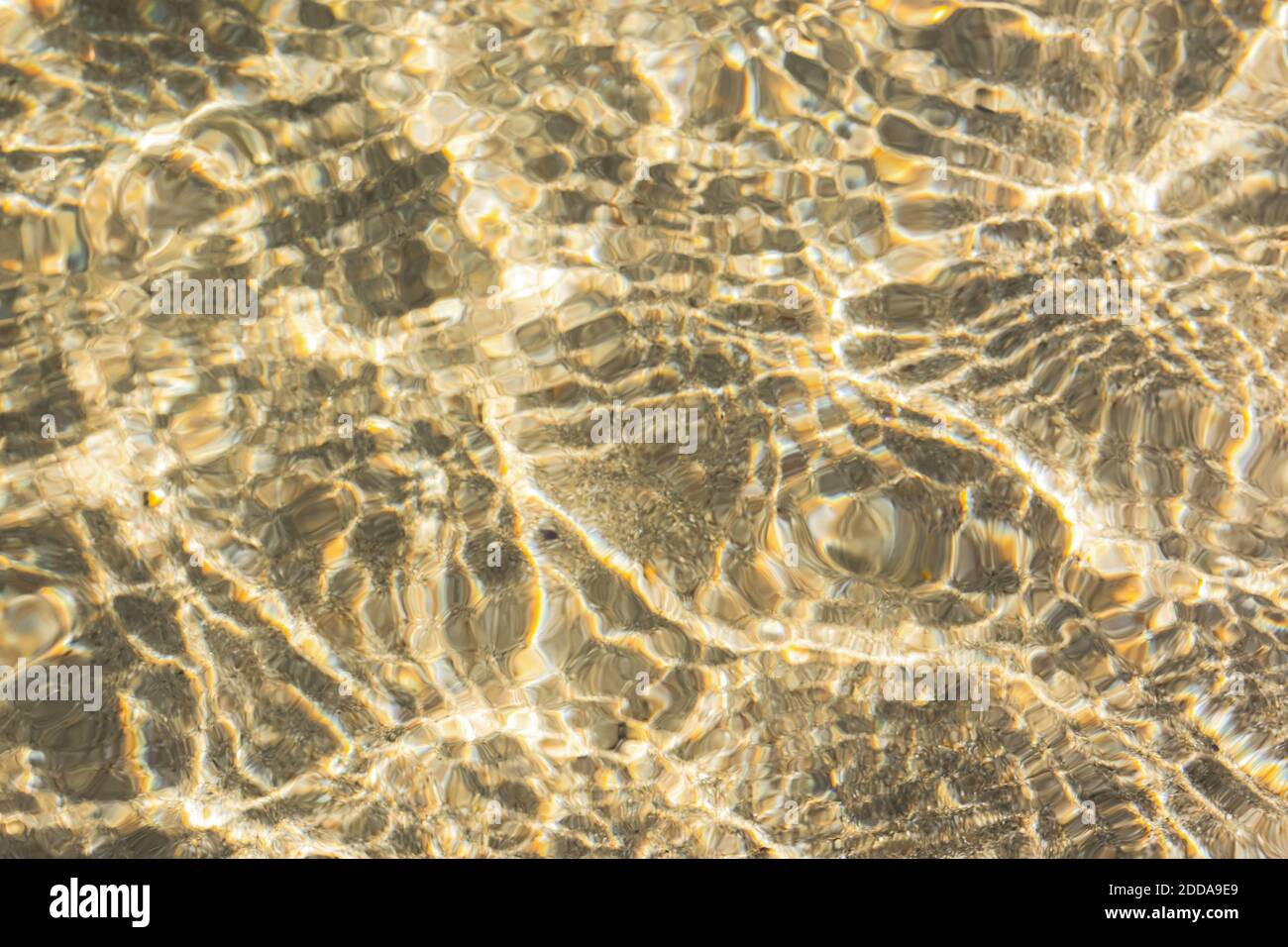 Consistenza di acqua di mare con sabbia. Trendy luce beige iridescente colore dell'acqua di mare. Set vela Champagne caldo mare sabbia al sole. Backgr. Naturale astratto Foto Stock