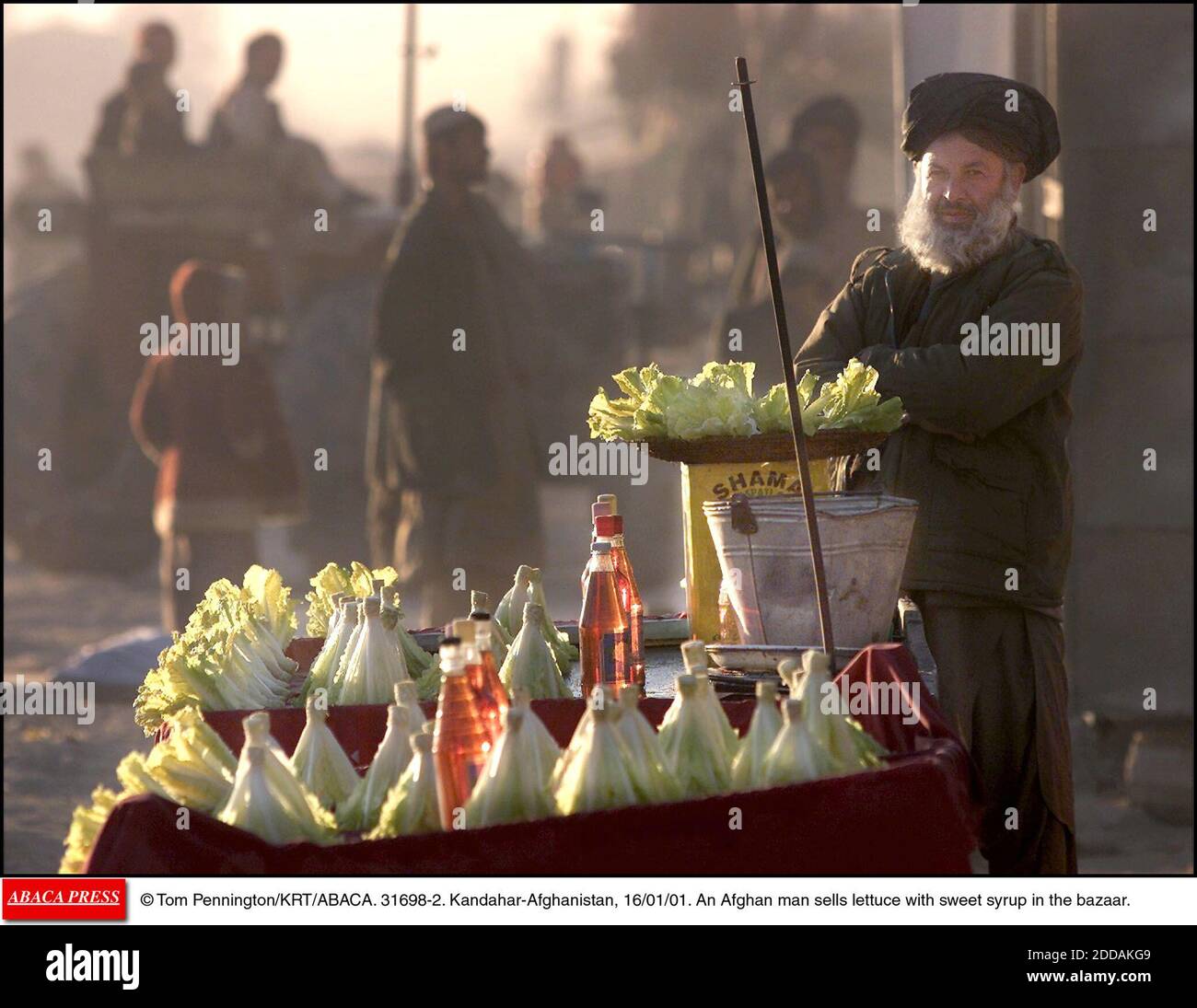 NESSUN FILM, NESSUN VIDEO, NIENTE TV, NESSUN DOCUMENTARIO - © TOM PENNINGTON/KRT/ABACA. 31698-2. Kandahar-Afghanistan, 16/01/01. Un uomo afgano vende lattuga con sciroppo dolce nel bazar. Foto Stock