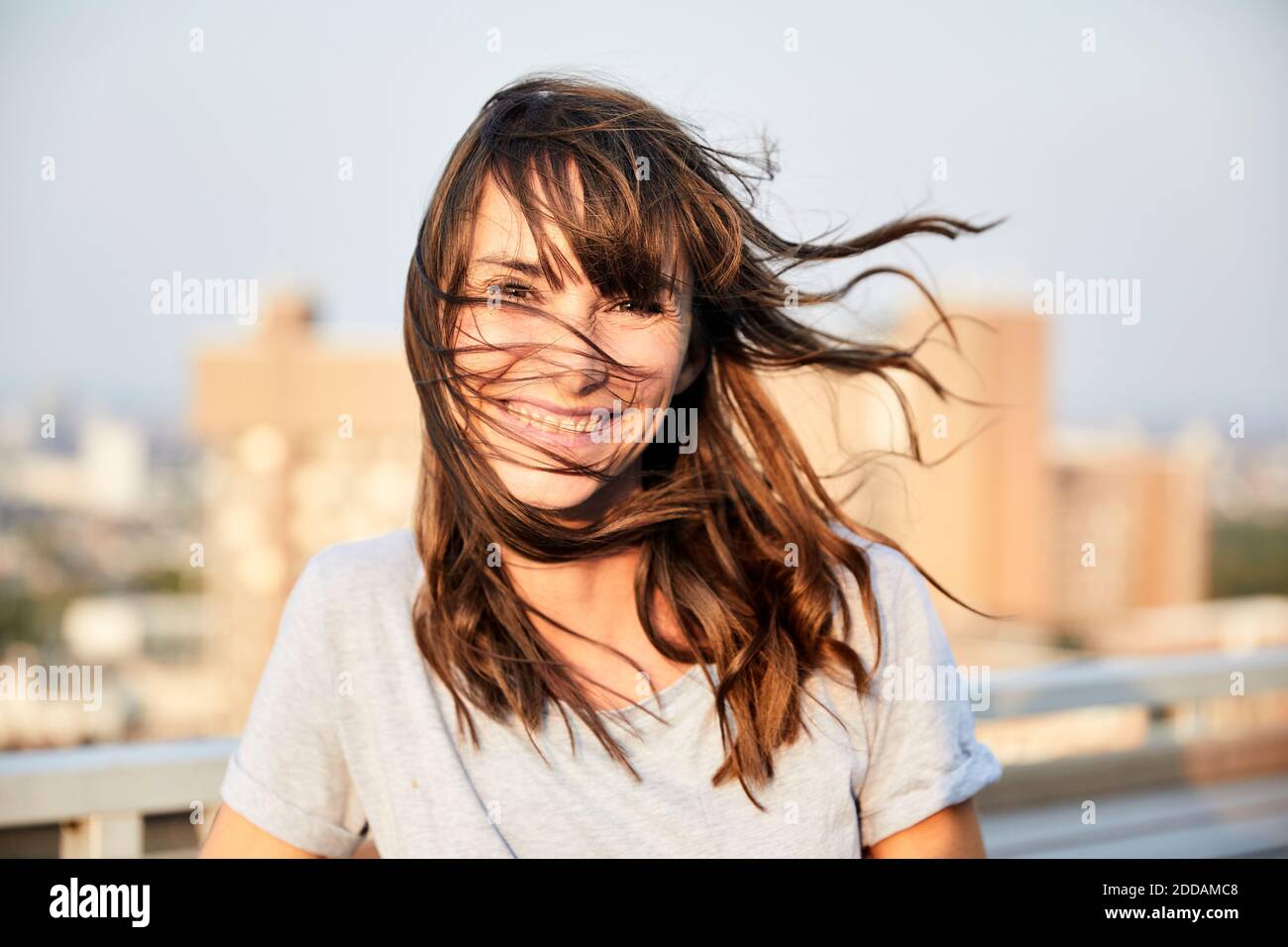 Donna matura con capelli che soffiano in piedi sulla terrazza dell'edificio Foto Stock