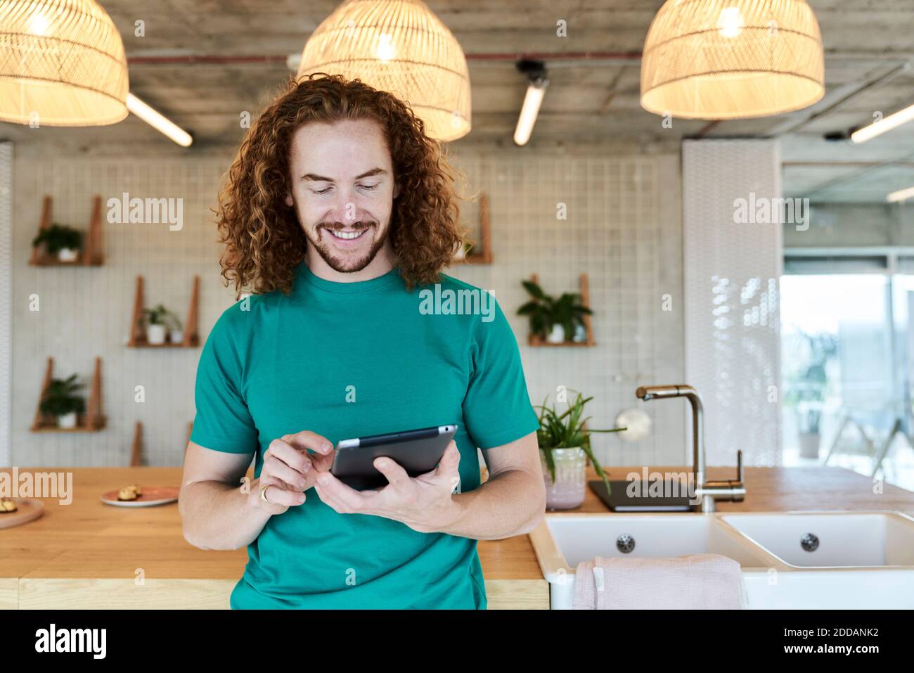 Bell'uomo che usa il tablet digitale mentre si trova in studio Foto Stock
