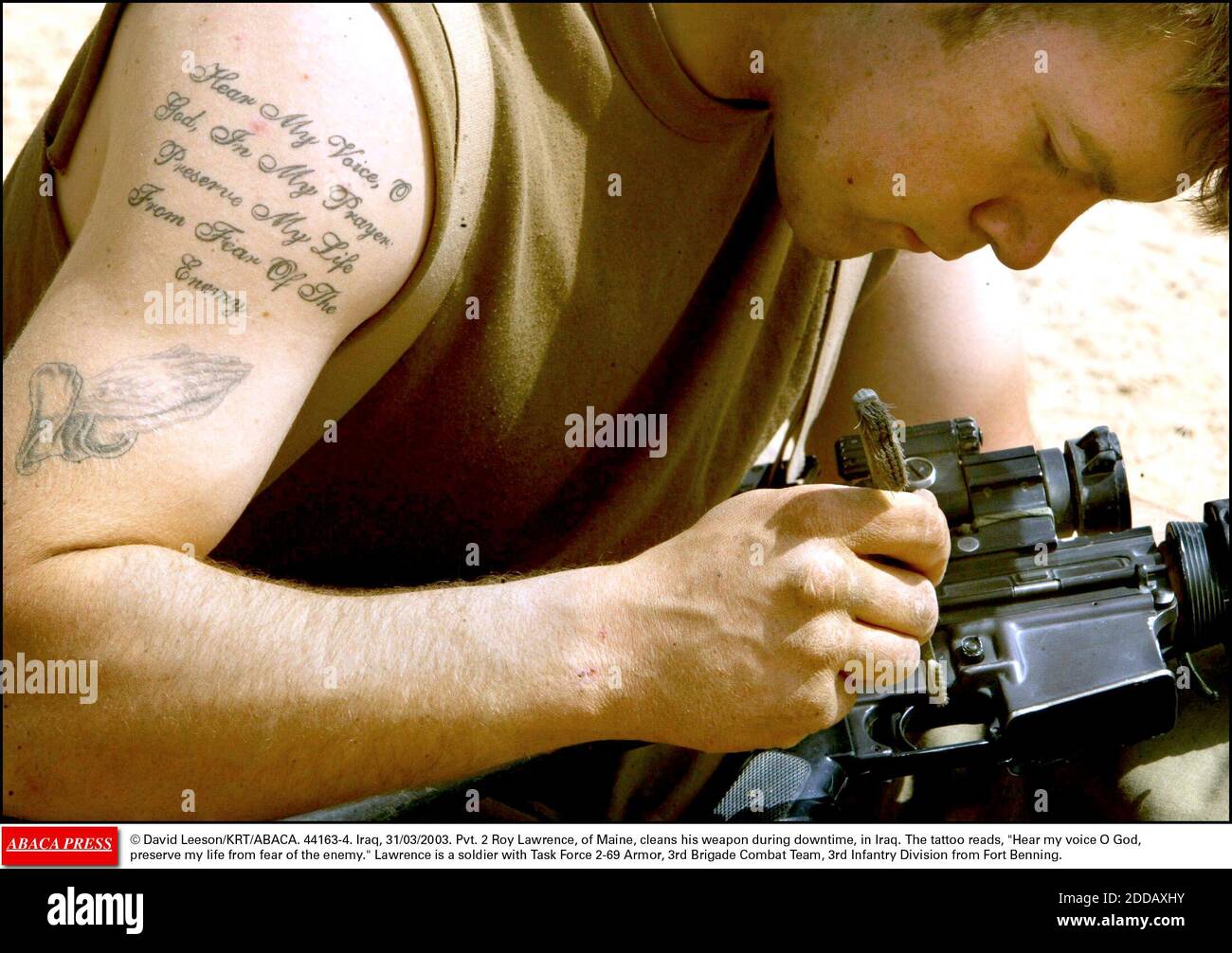 NESSUN FILM, NESSUN VIDEO, NESSUNA TV, NESSUN DOCUMENTARIO - © DAVID LEESON/KRT/ABACA. 44163-4. Iraq, 31/03/2003. Pvt. 2 Roy Lawrence, del Maine, pulisce la sua arma durante il periodo di inattività, in Iraq. Il tatuaggio legge, ascolta la mia voce o Dio, preserva la mia vita dalla paura del nemico. Lawrence è un soldato con Task Force 2-69 Armo Foto Stock