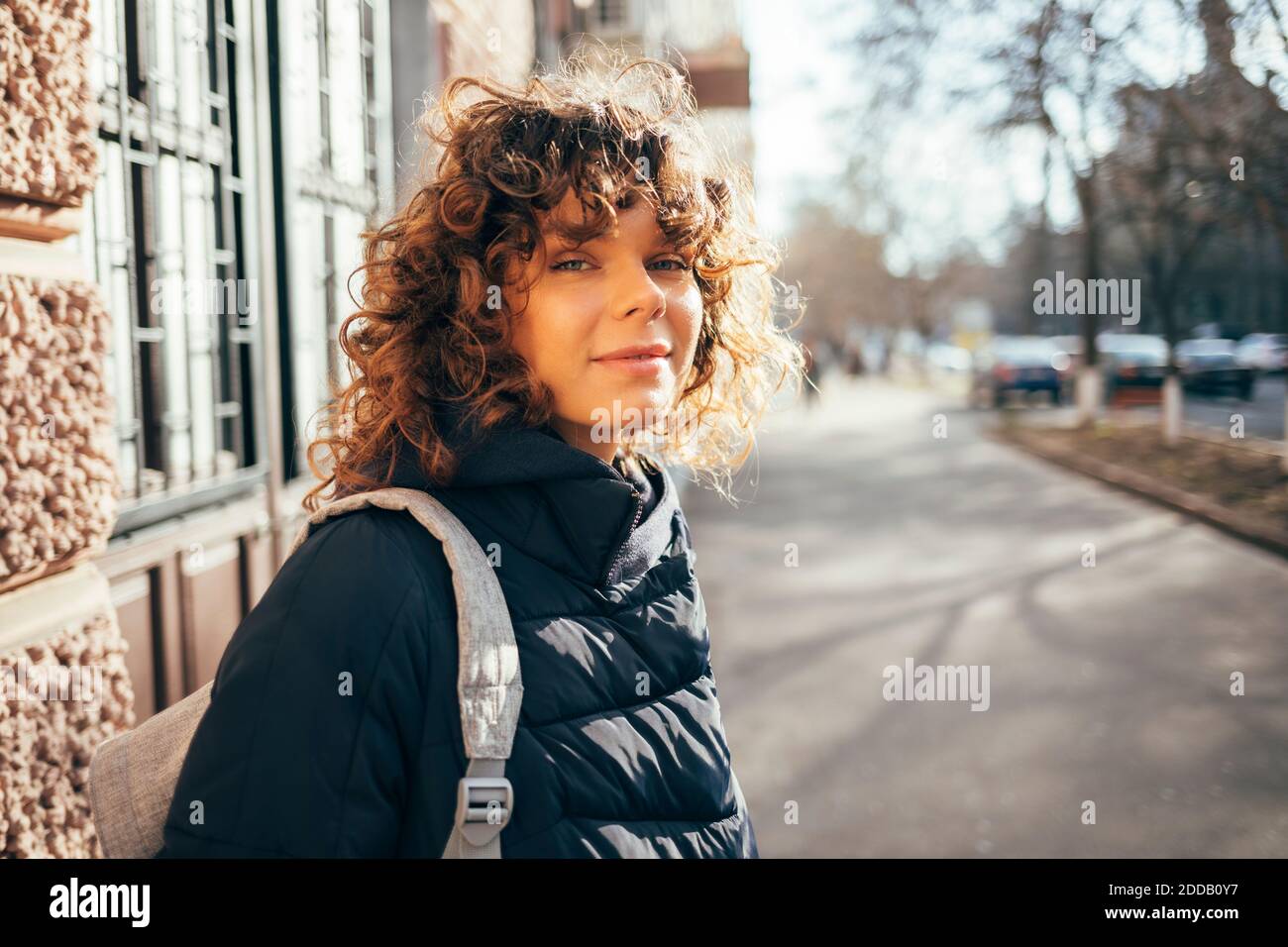 Donna mid adult in piedi sul marciapiede in città Foto Stock