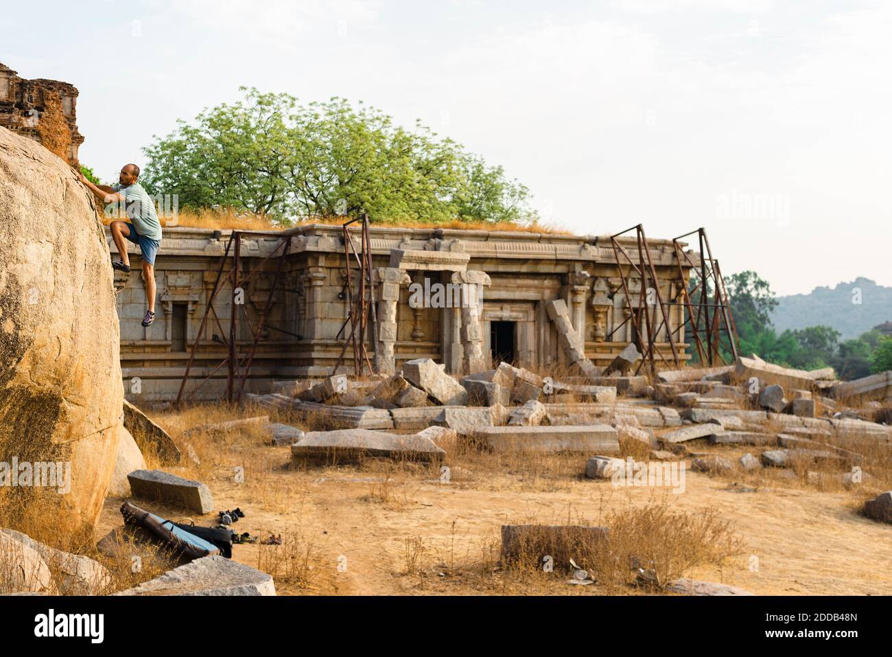 Masso da arrampicata maschile ad Hampi, Karnataka, India durante il tramonto Foto Stock