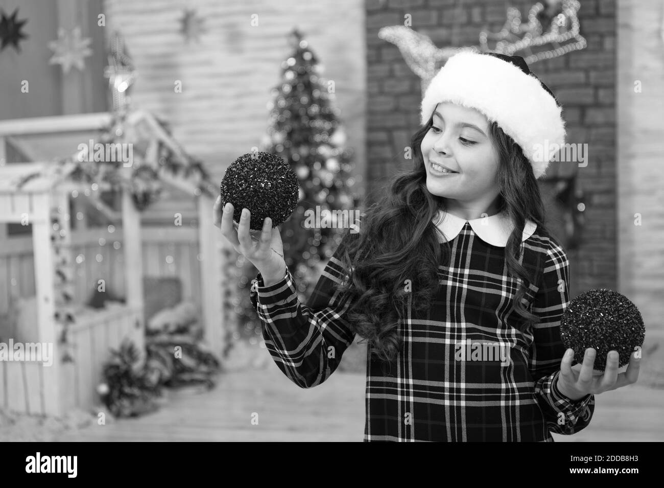 È così grande. mattina prima di natale. Felice anno nuovo bambino in santa hat. attività invernale. shopping natalizio. piccola ragazza elf costume. alla moda decorativa di capretto xmas palla. home e albero di Natale decorazioni. Foto Stock