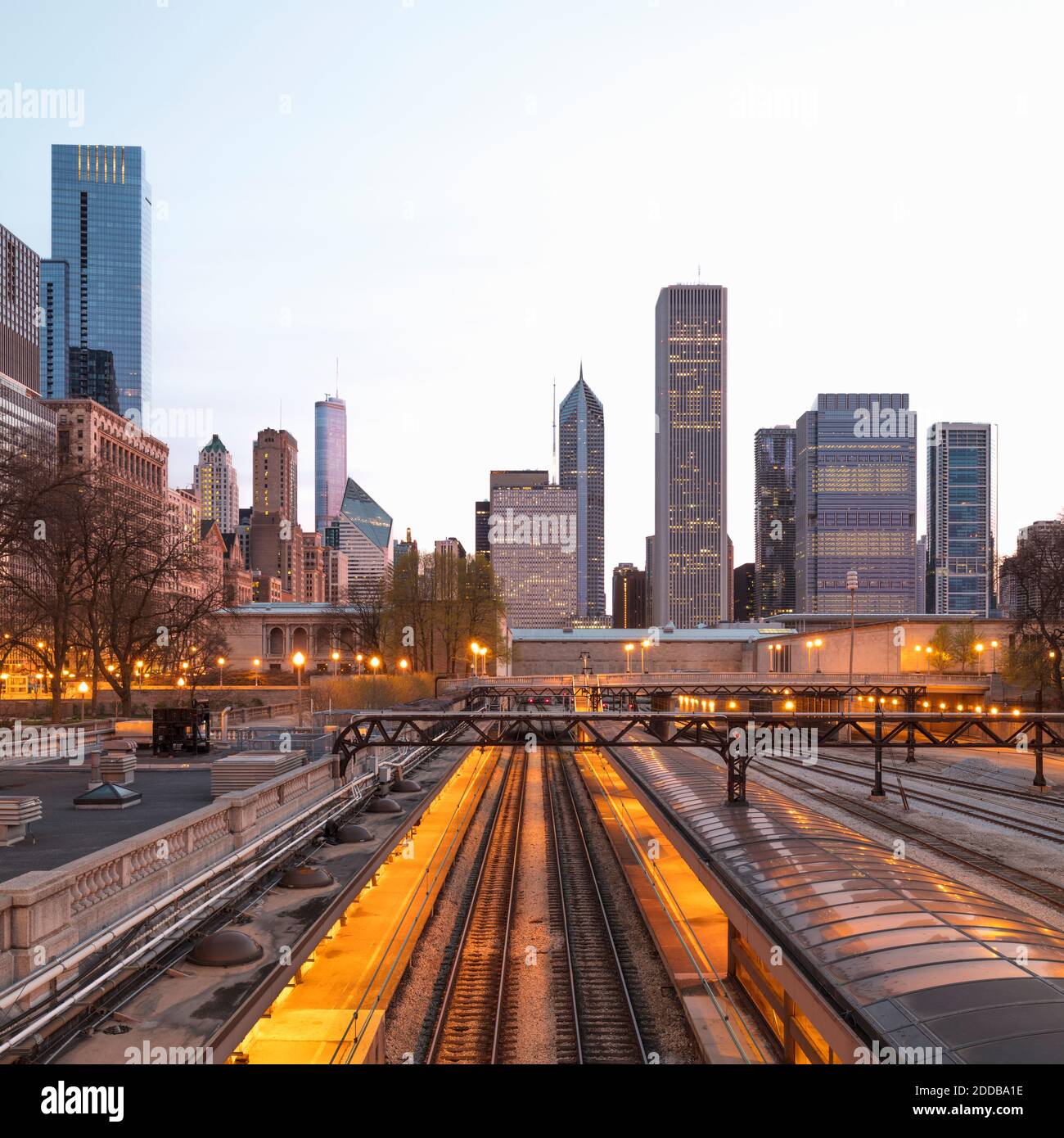 Binari ferroviari illuminati contro gli edifici della città di Chicago, Stati Uniti Foto Stock