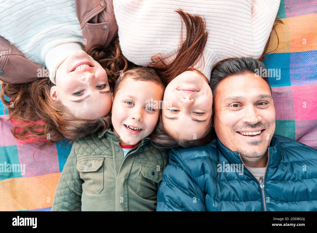 Direttamente sopra la vista di una famiglia sorridente che si stese per un picnic coperta nel parco Foto Stock