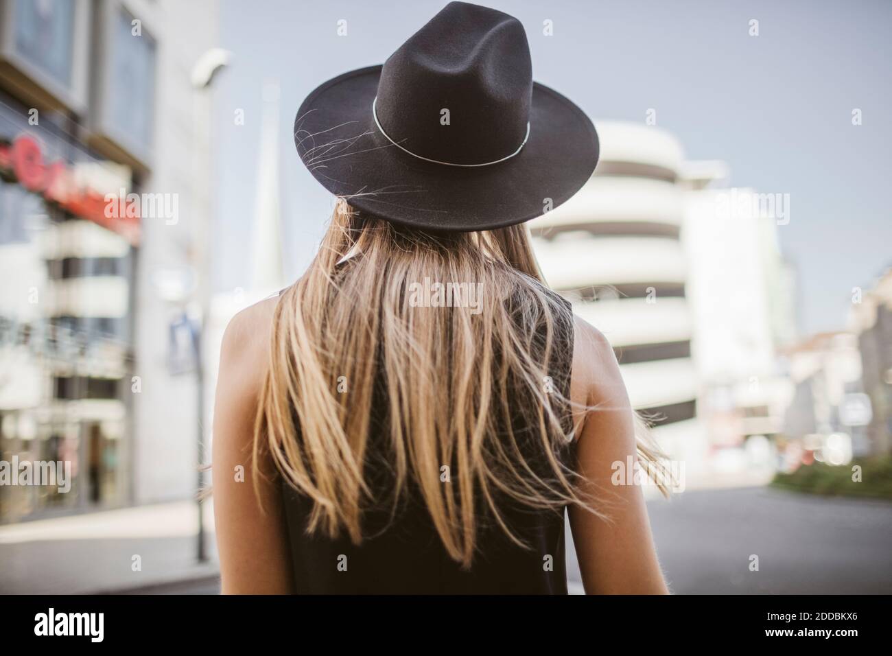 Donna con capelli lunghi biondi in piedi in città Foto Stock