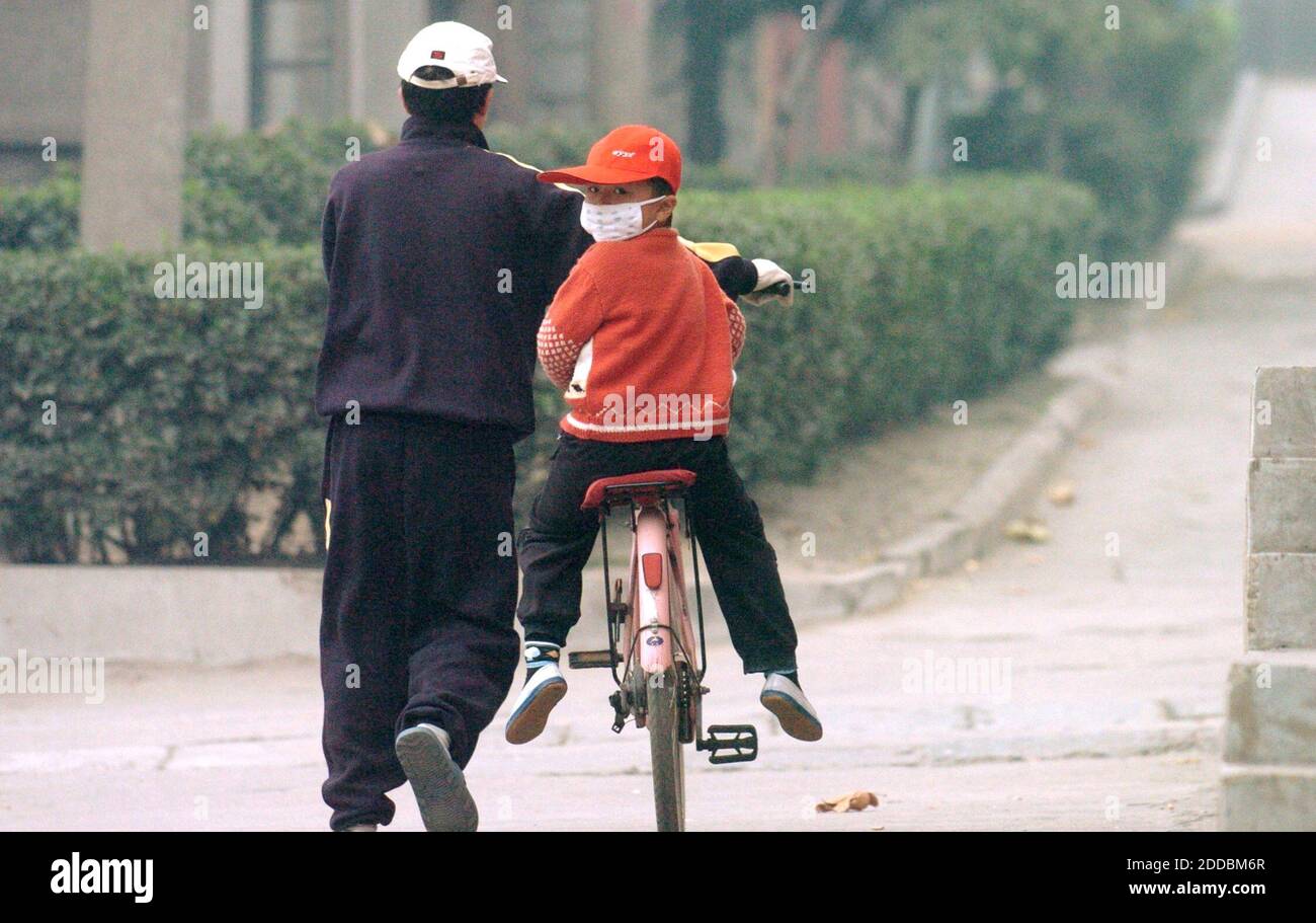 NESSUN FILM, NESSUN VIDEO, NESSUNA TV, NESSUN DOCUMENTARIO - UN padre e un figlio lasciano il dormitorio dell'acciaio di Laiwu, 5 novembre 2005 durante un giorno in cui la qualità dell'aria nel nord della Cina era molto povera. Laiwu Steel Group stava scavando il suo secondo impianto principale dalle colline nella provincia rurale di Shandong, quando il congressista statunitense Jim Oberstar, un democratico della catena del ferro del Minnesota, aiutò a negoziare un accordo per l'acciaieria cinese e un fornitore di minerali con sede in Ohio per acquistare una miniera di taconite del Minnesota fuori dal fallimento. Foto di Sherri Larose/St Paul Pioneer Press/KRT/ABACAPRESS.COM Foto Stock