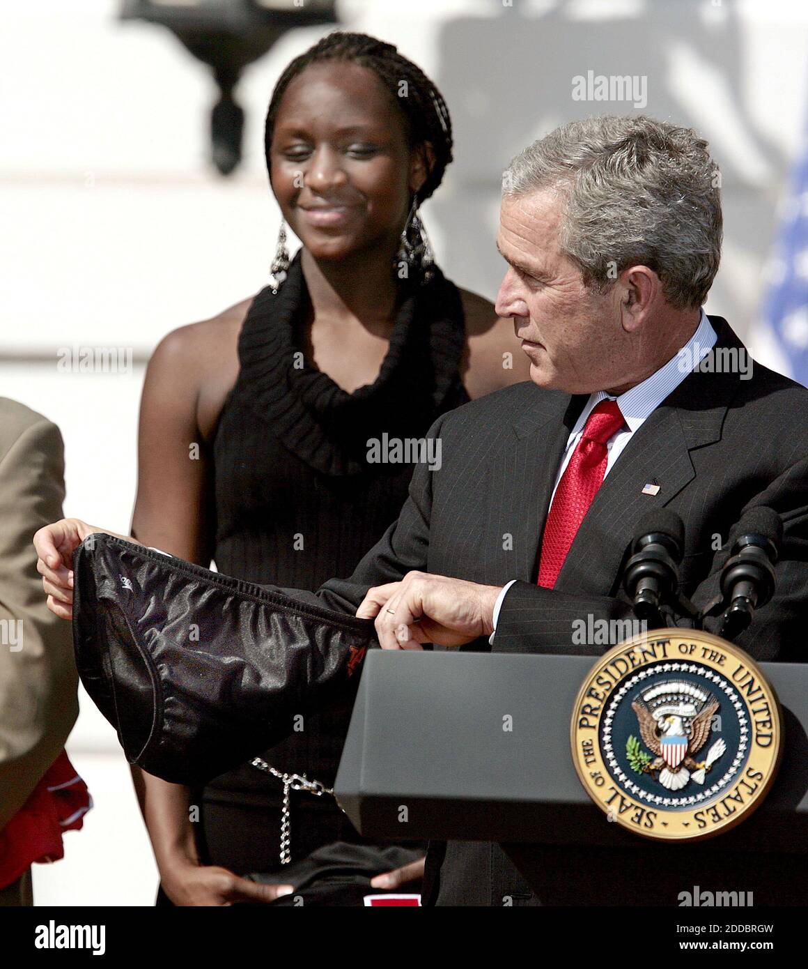 NESSUN FILM, NESSUN VIDEO, NESSUN TV, NESSUN DOCUMENTARIO - il giocatore di basket femminile dell'Università del Maryland Crystal Langhorne guarda come il presidente George W. Bush viene presentato con un costume da bagno dalla squadra di nuoto di Auburn mentre si congratula con 12 squadre della National Collegiate Athletic Association (NCAA) per aver vinto titoli nazionali durante le stagioni 2005 e 2006 sul South Lawn of the White House a Washington, DC, USA, il 6 aprile 2006. Foto di Chuck Kennedy/KRT/ABACAPRESS.COM Foto Stock