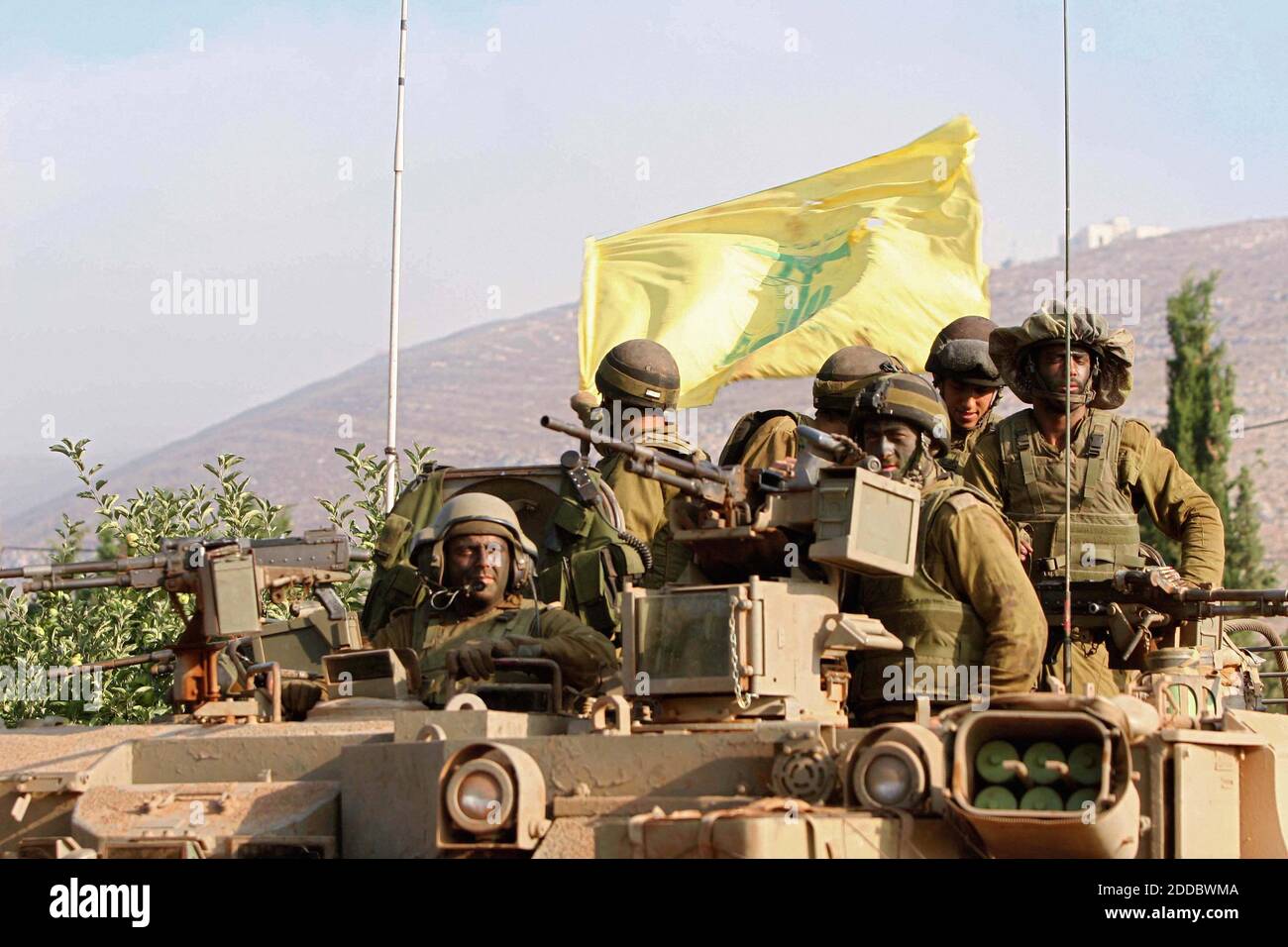 NO FILM, NO VIDEO, NO TV, NO DOCUMENTARIO - i soldati israeliani ondeggiano una bandiera di Hezbollah infranta al ritorno di mattina presto Giovedi, 27 luglio 2006, dai combattimenti intorno al villaggio libanese meridionale di Marun al-Ras a una posizione lungo il confine nordorientale di Israele con il suo vicino. Il ministro israeliano della Giustizia Haim Ramon ha affermato oggi che i colloqui internazionali di Roma, che ieri si sono interrotte senza un accordo su una richiesta di cessate il fuoco, hanno dato ad Israele l'"autorizzazione" a esercitare pressioni sulla sua offensiva in Libano. Foto di Pierre Tjerdman/Flash 90/MCT/ABACAPRESS.COM Foto Stock