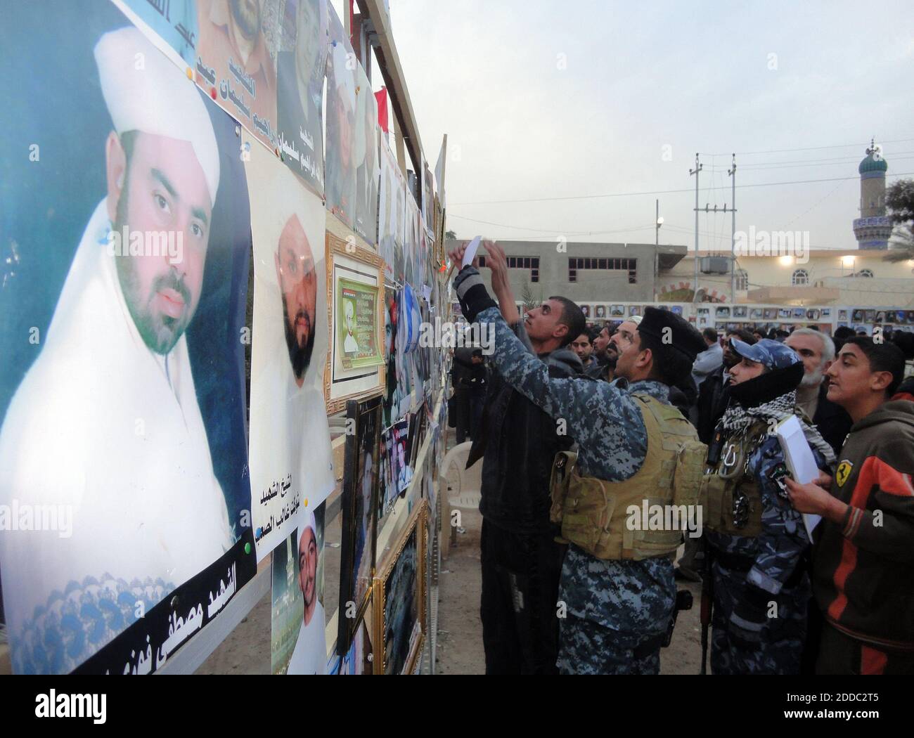 NESSUN FILM, NESSUN VIDEO, NESSUNA TV, NESSUN DOCUMENTARIO - al 'muro dei 'martiri' di Fallujah, i membri dei servizi di sicurezza iracheni cercano fotografie di parenti morti, 15 dicembre 2011. Foto di Jamal Naji/MCT/ABACAPRESS.COM Foto Stock