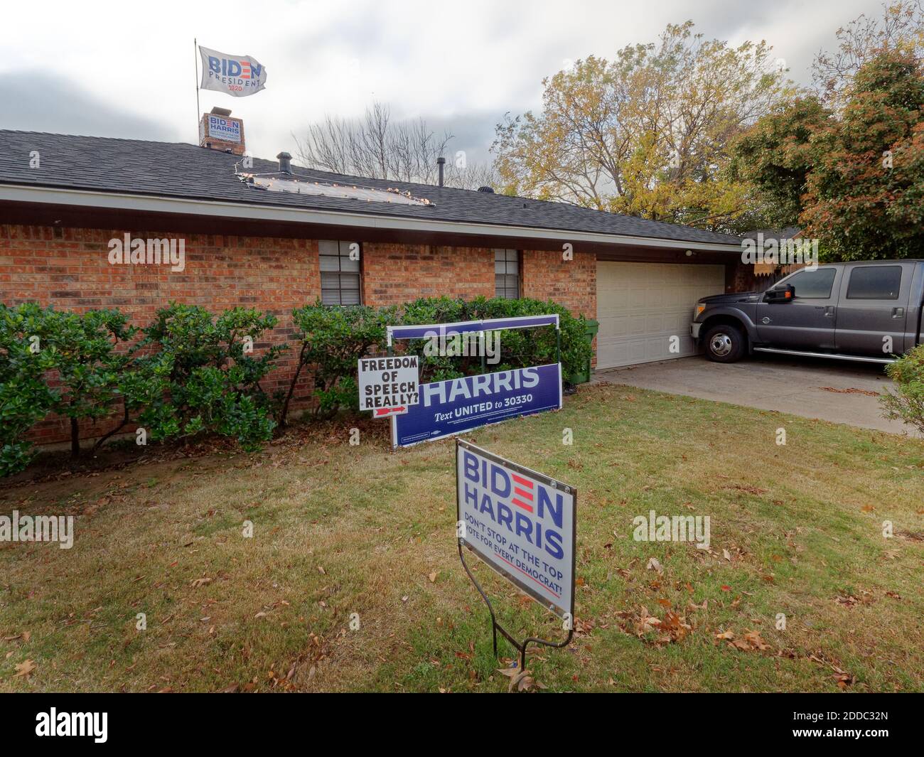 Arlington, Texas-24 Nov 2020: Il segno della campagna di Biden ha fatto la sua faccia nel prato dei proprietari di case in un sobborgo conservatore pro-Trump Texas fuori Dallas, Texas. Con l'ex vice-presidente degli Stati Uniti Joe Biden che ha vinto le elezioni presidenziali del 2020, un proprietario di abitazione pubblica "la libertà di parola realmente?" Firmi con la bandiera eletta di Biden che batte in alto fuori della portata dei supporti di Trump. Durante la posa Trump sostiene il cartello nel cortile anteriore, tagliando il nome di Biden. (Impossibile rimuovere il segno, ma in grado di tagliare il nome Biden) Foto Stock
