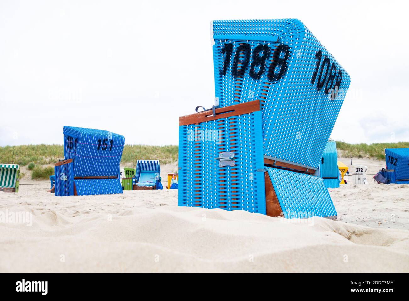 Sedie da spiaggia con cappuccio sulla spiaggia sabbiosa costiera dell'isola di Langeoog Foto Stock