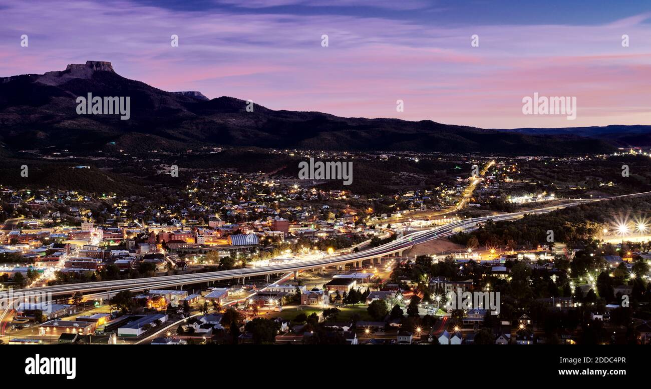 USA, Colorado, Trinidad, Interstate 25 che si estende attraverso la città illuminata di notte con Fishers Peak sullo sfondo Foto Stock