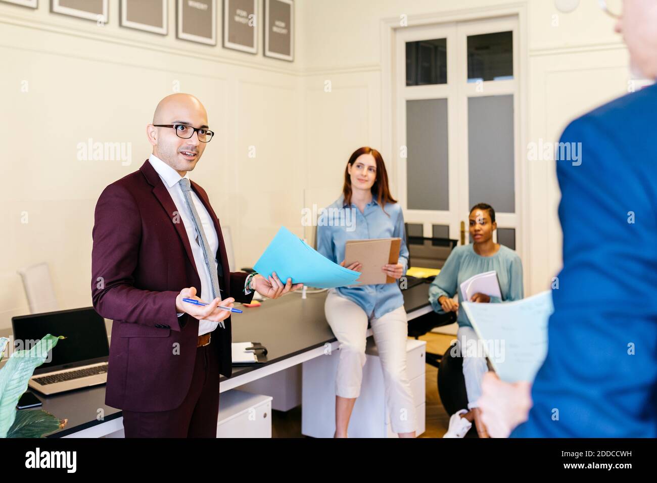 Imprenditore che discute le strategie di affari con i colleghi sul posto di lavoro Foto Stock