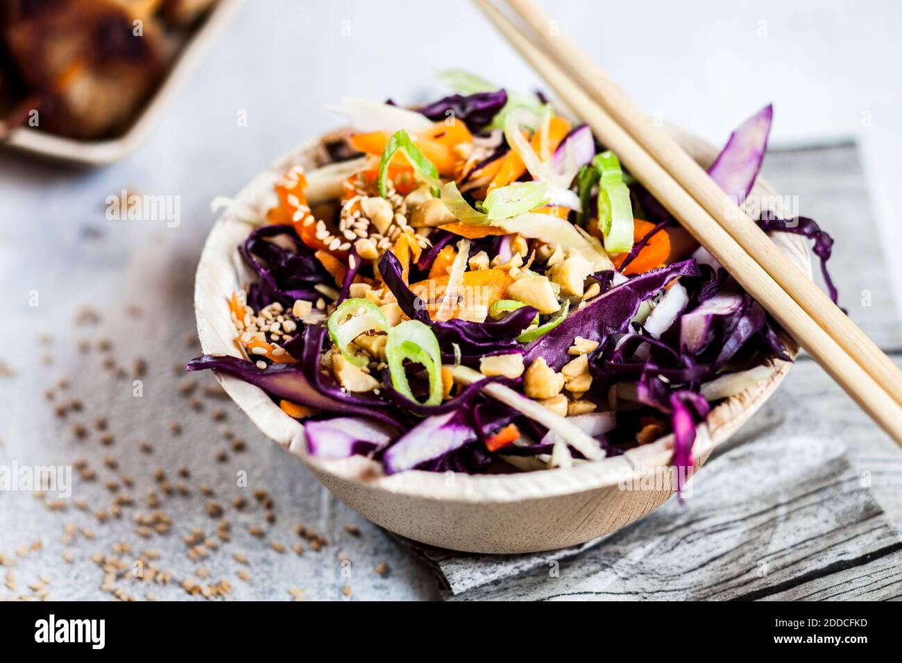 Primo piano di ciotola vietnamita per insalata di cavolo con bastoncini sul tavolo Foto Stock