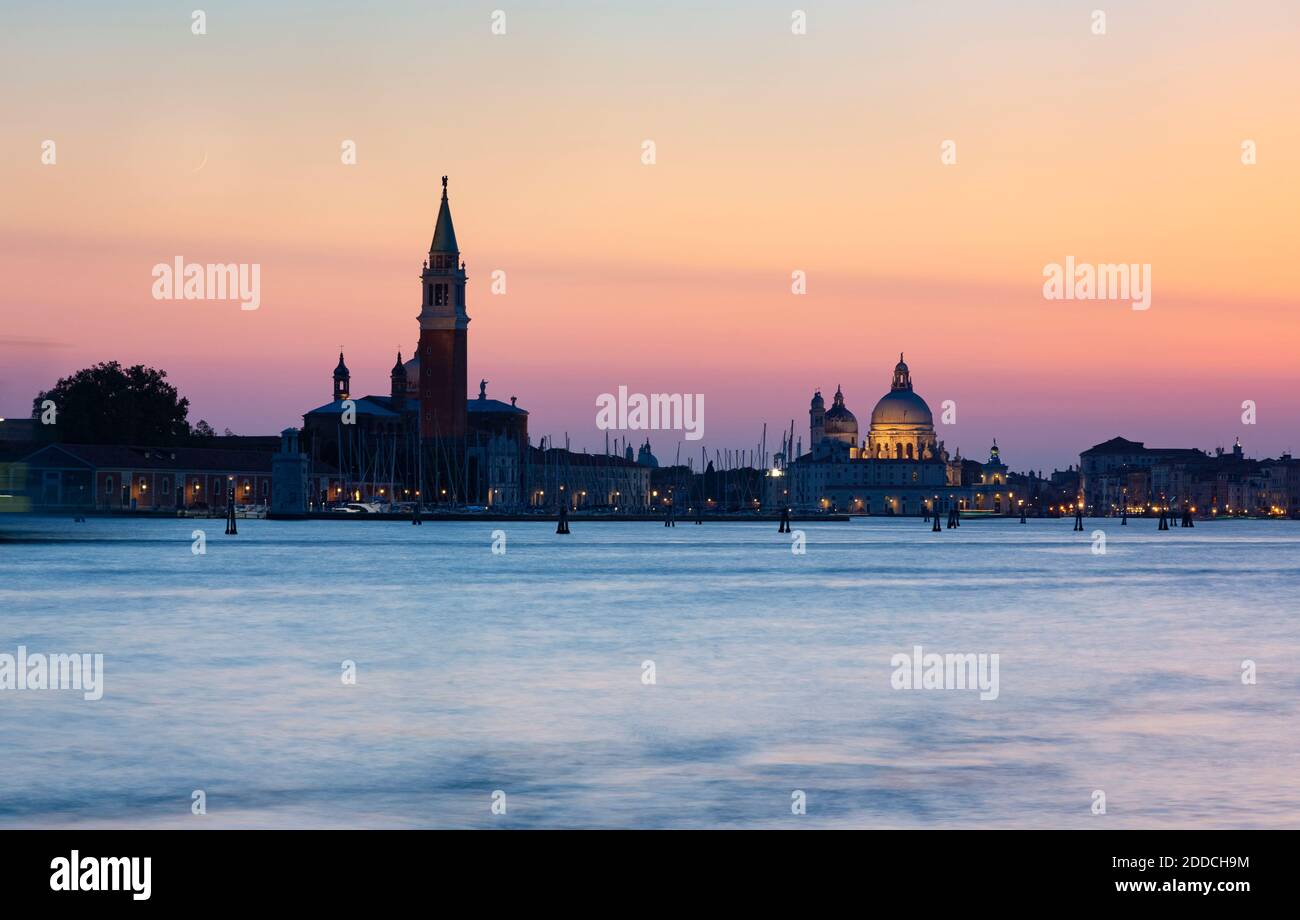Italia, Veneto, Venezia, lungomare veneziano al tramonto con le chiese di Santa Maria della Salute e San Giorgio maggiore sullo sfondo Foto Stock