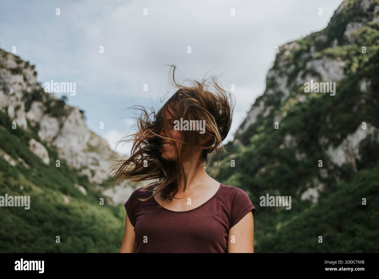 Donna mid adulta con capelli castani lunghi tosati contro la montagna intervallo Foto Stock