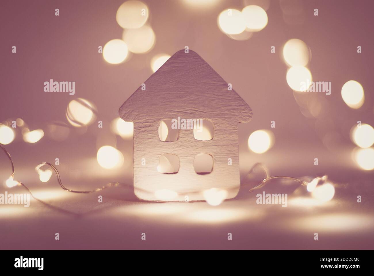 piccola casa con luci di natale ghirlanda, sfondo vacanze invernali Foto Stock