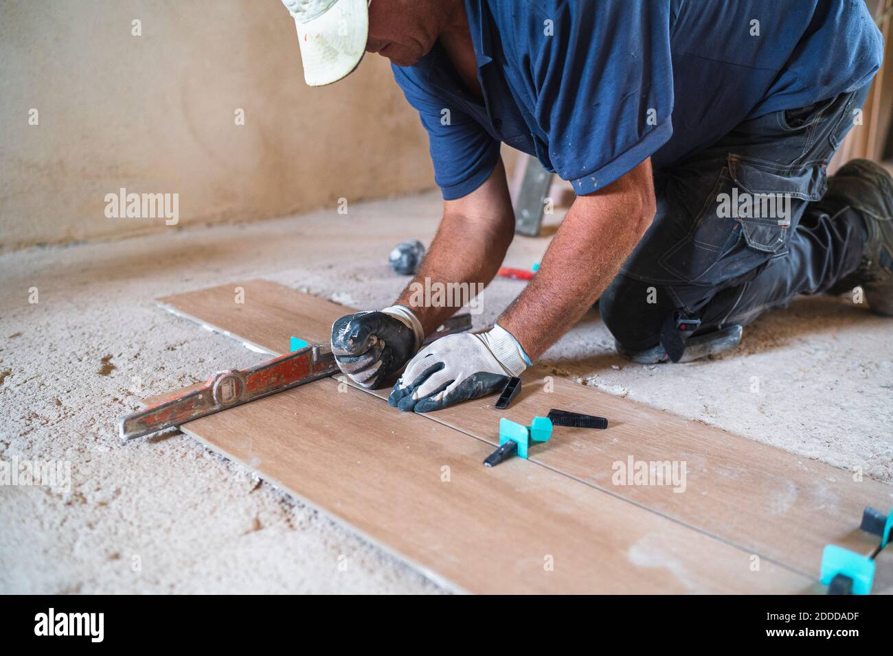 Uomo lavoratore manuale di installazione parquet pavimento in casa Foto Stock