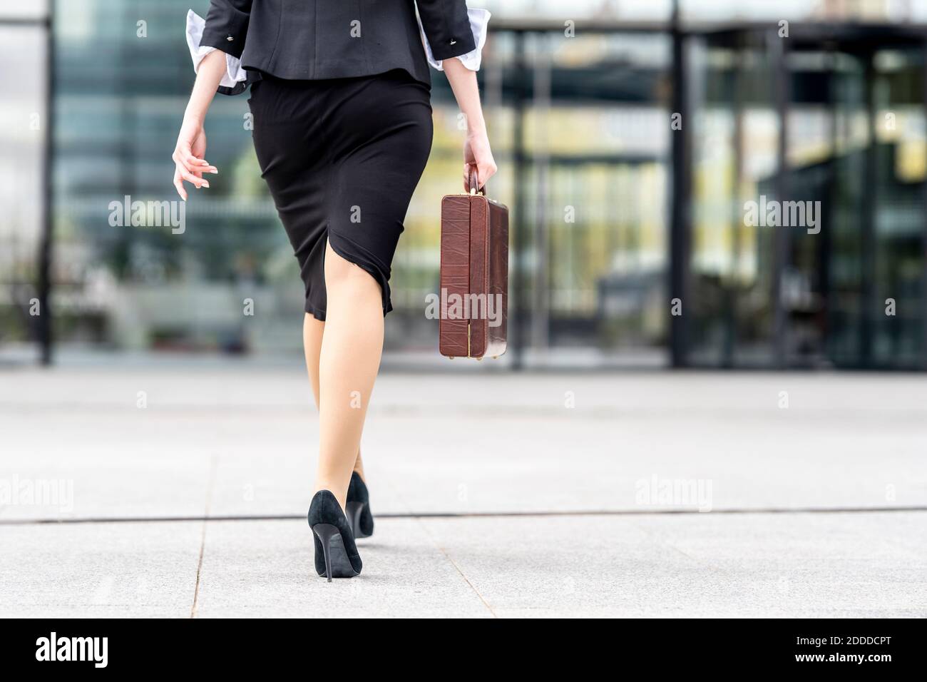 Donna d'affari che indossa tacchi alti che cammina con la valigetta sul  sentiero Foto stock - Alamy