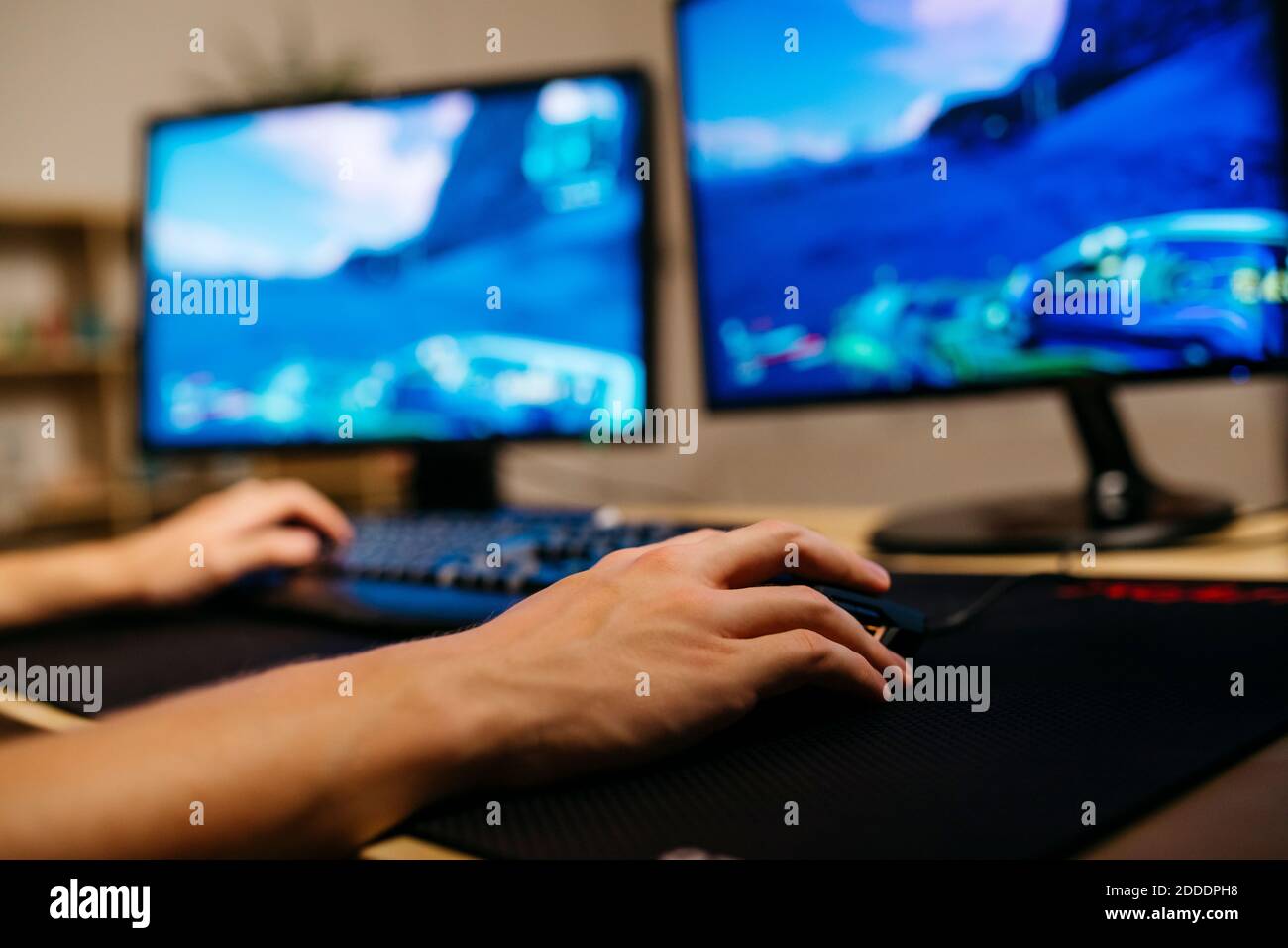 Giovane uomo che gioca a videogiochi con il computer alla scrivania Foto Stock