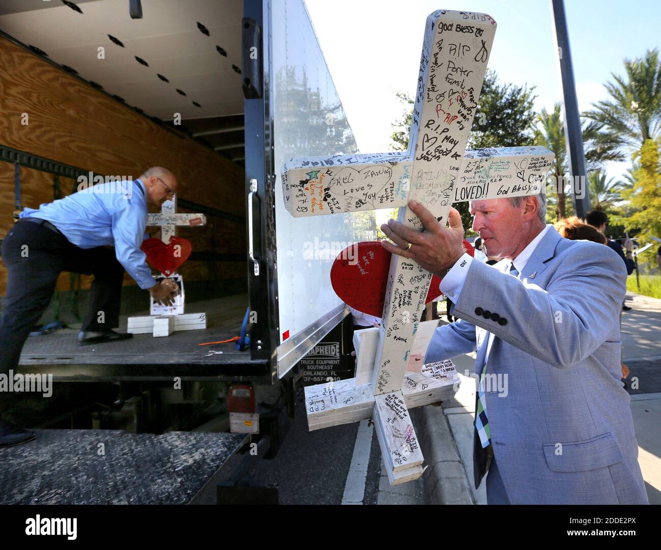 NESSUN FILM, NESSUN VIDEO, NESSUNA TV, NESSUN DOCUMENTARIO - nel mese di anniversario del massacro di Pulse nightclub ad Orlando, FL, USA., il sindaco Buddy Dyers consegna una delle croci erette per onorare le vittime di Michael Perkins, a sinistra, del Centro di Storia Regionale della Contea di Orange, Durante una cerimonia sommera al Centro medico Regionale di Orlando, vicino al club, martedì 12 luglio 2016. Le 49 croci sono state fatte da un falegname di Chicago per onorare ciascuna delle vittime uccise a Pulse il 12 giugno. Le croci saranno esposte in modo permanente presso il centro storico nel centro di Orlando. Foto di Joe Burbank/Orlando Foto Stock