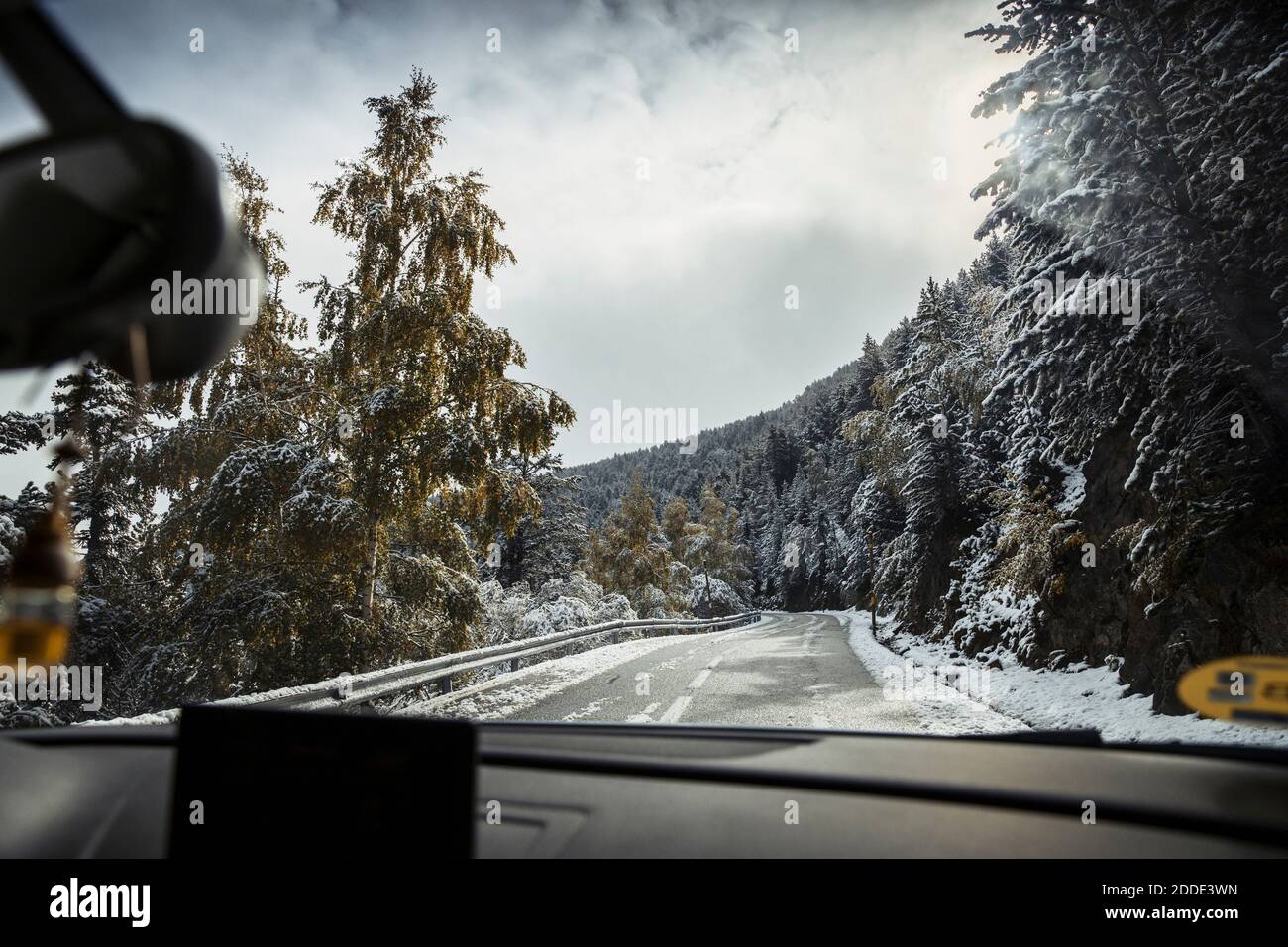 Vista dall'auto che guida lungo l'autostrada alpina in inverno Foto Stock