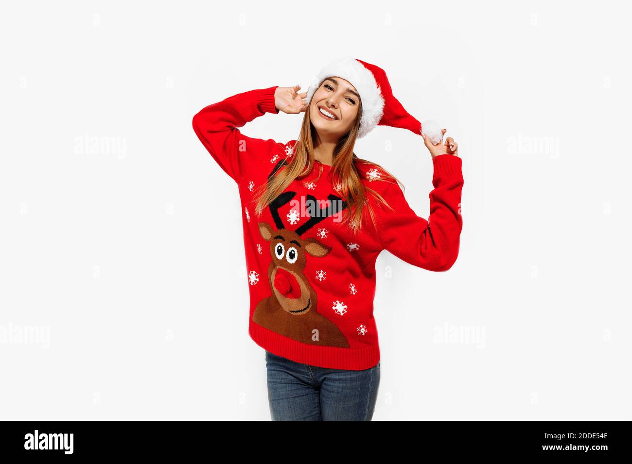 Felice giovane donna carina in felpa di natale e cappello di babbo natale,  su sfondo bianco Foto stock - Alamy