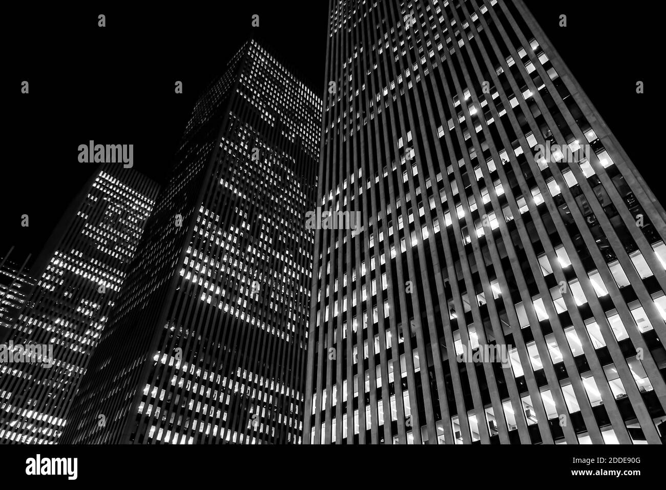 Edifici moderni illuminati nel quartiere del centro di notte, New York, Stati Uniti Foto Stock