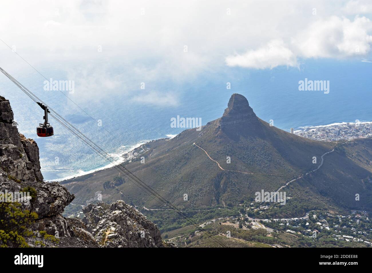 Vista della funivia che raggiunge la stazione superiore della funivia di Table Mountain, Città del Capo. La montagna Lions Head e l'Oceano Atlantico sono sullo sfondo Foto Stock