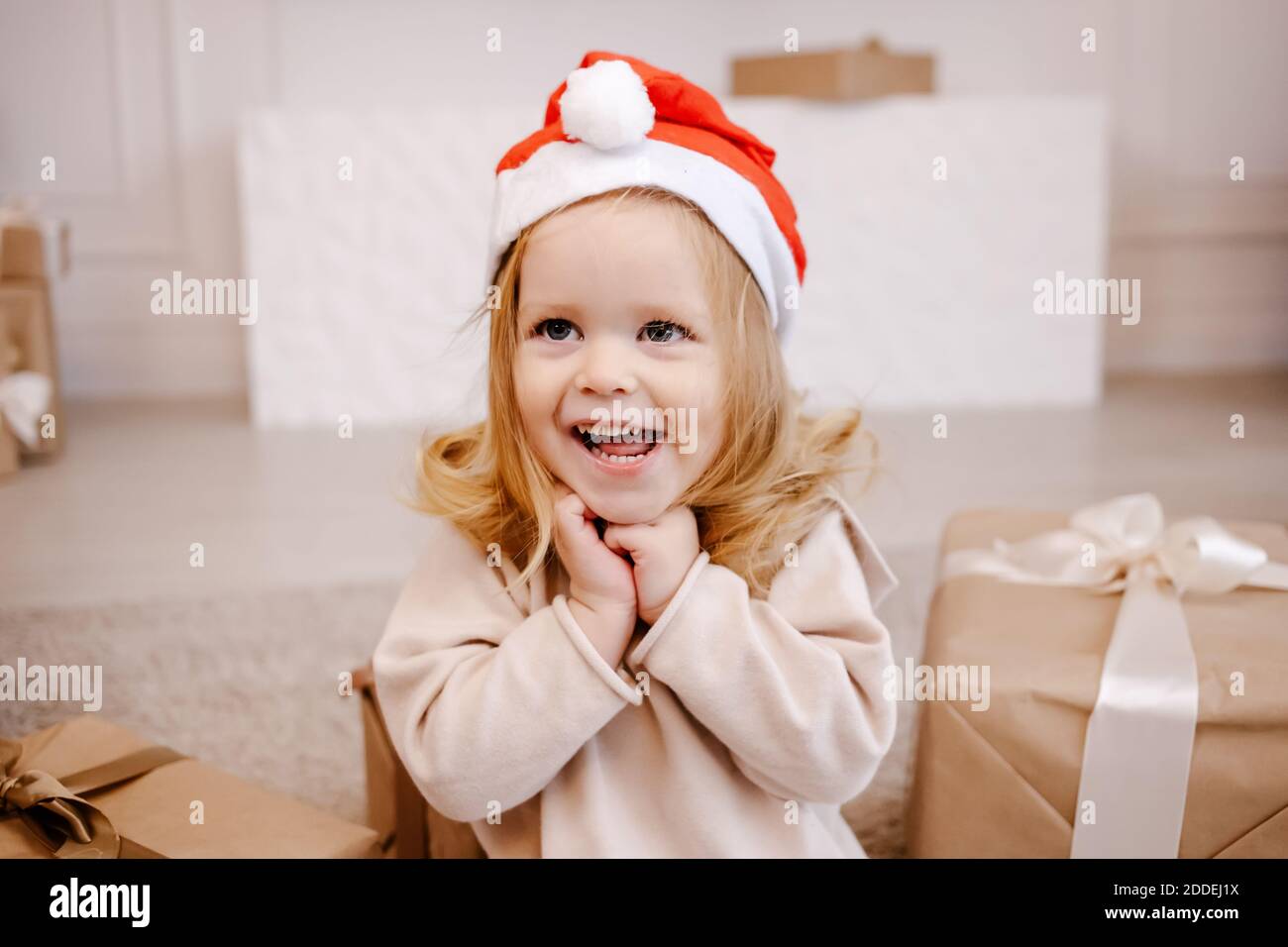 Divertente bambina in attesa di sorpresa dalla confezione regalo. Foto Stock