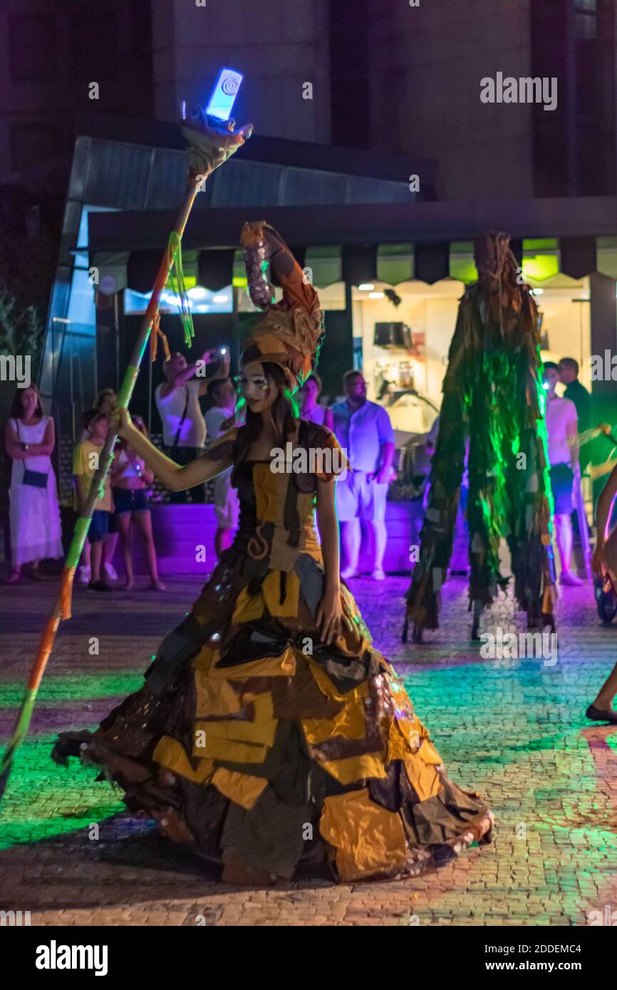 Artisti di strada movimento circo con musicisti e abiti donne con un grande bastone di legno e luce Foto Stock