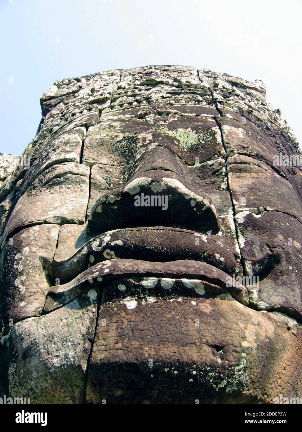 Grande pietra dettagliata scolpito faccia a Bayon, Cambogia, fa parte del complesso Angkor Thom che comprende oltre 200 delle enormi facce serene. Noti per l'architettura barocca Khmer, i volti sono diventati un simbolo dell'orgoglio cambogiano nel suo patrimonio culturale. Foto Stock