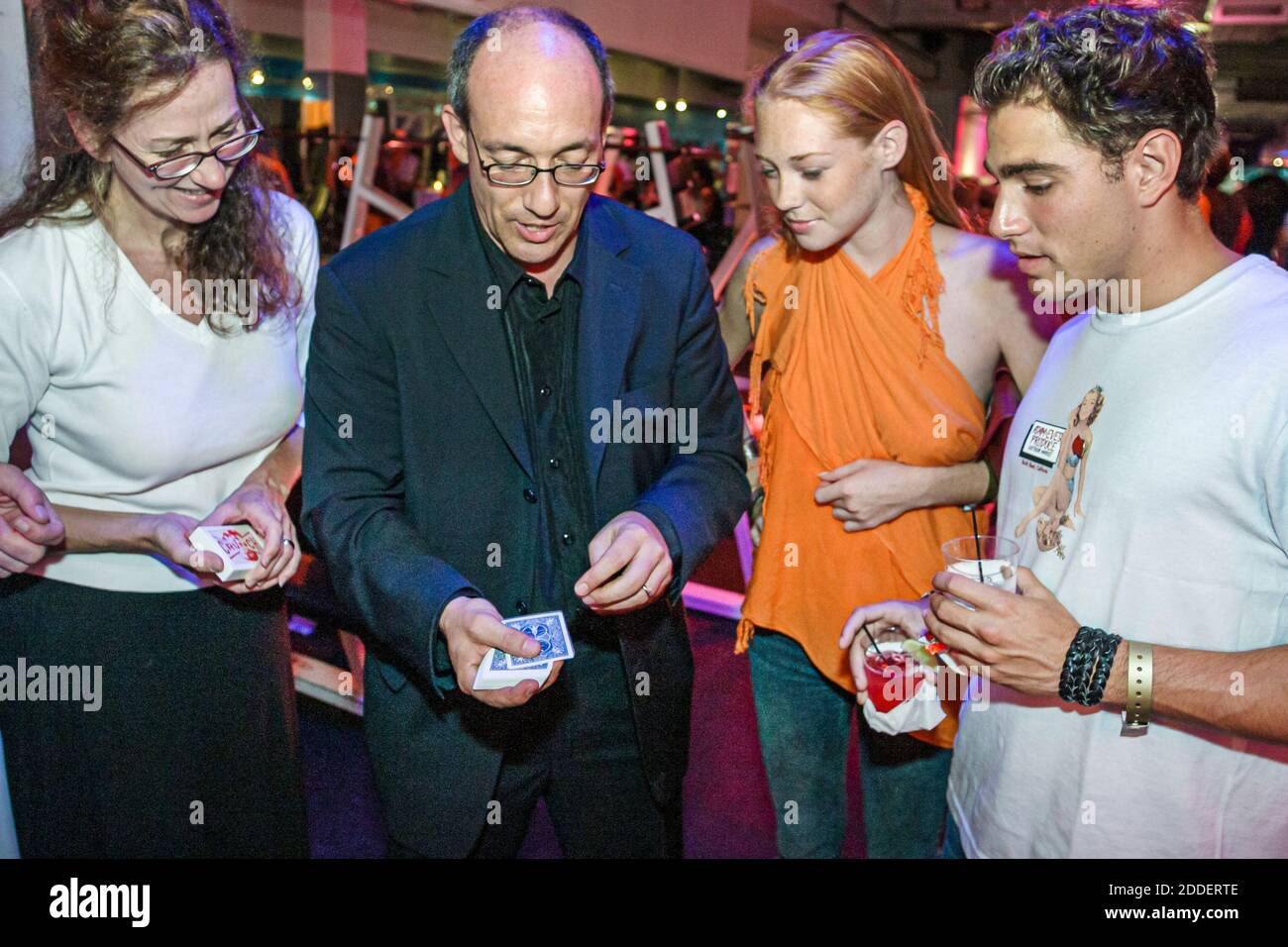 Miami Beach Florida, Crunch Gym VIP Party, intrattenimento notturno mago dimostra trucco carta, uomo donna orologi femmina, Foto Stock