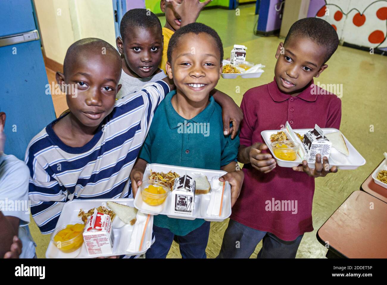 Miami Florida,Little Haiti Edison Park Elementary School,studenti ragazzi neri amici caffetteria pranzo vassoio, Foto Stock