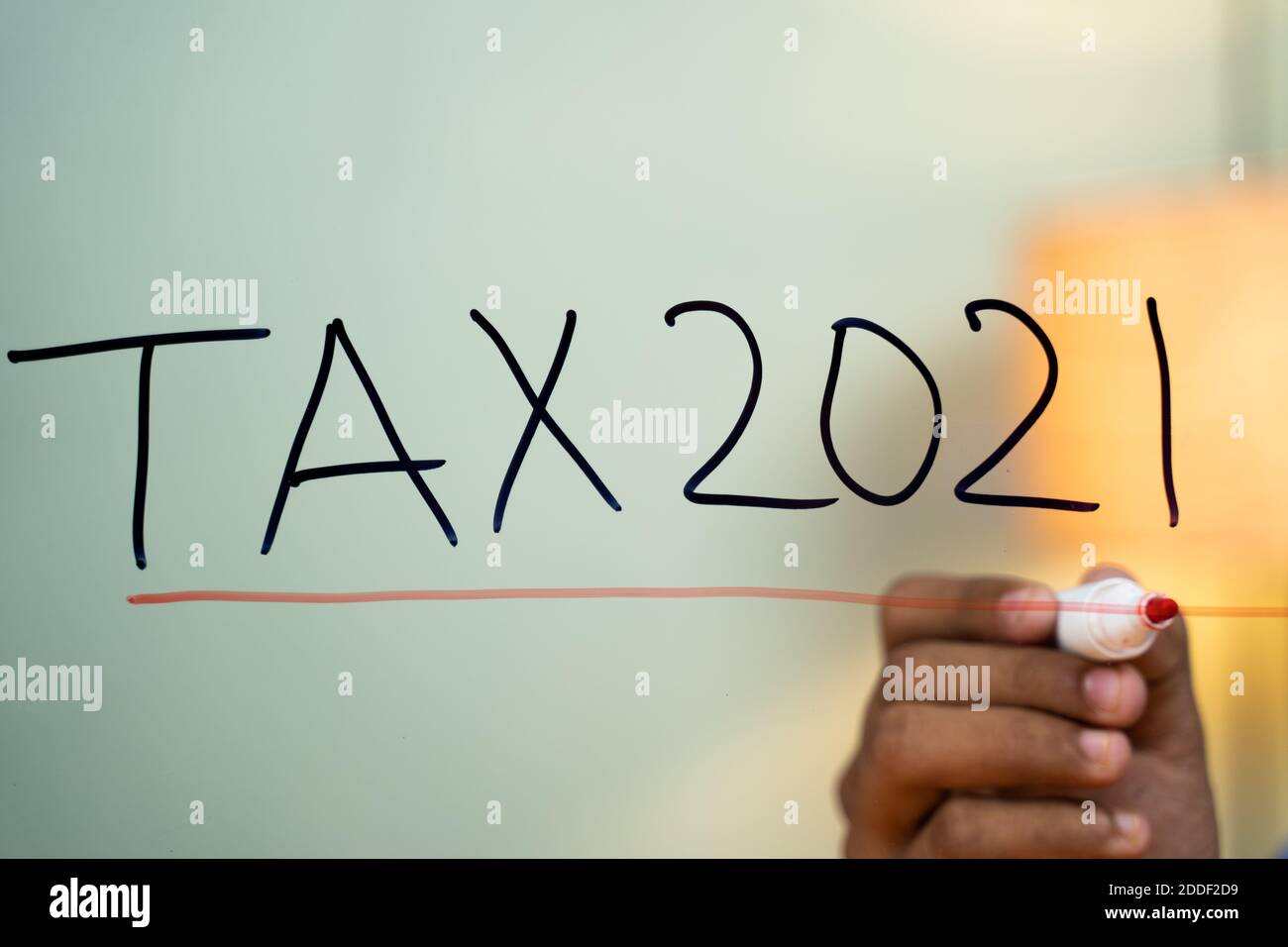 Linea di marcatura mani sul test Tax 2021 scritto su vetro - concetto di pagamento e di rendimento delle imposte per il nuovo anno 2021 concetto Foto Stock