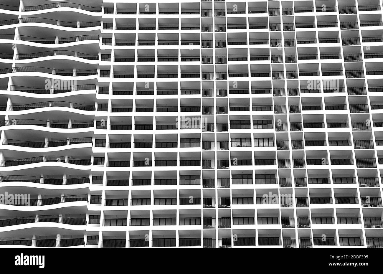 Moderno e contemporaneo edificio di appartamenti con linee curve a contrasto e rettilinee orizzontali. Foto Stock