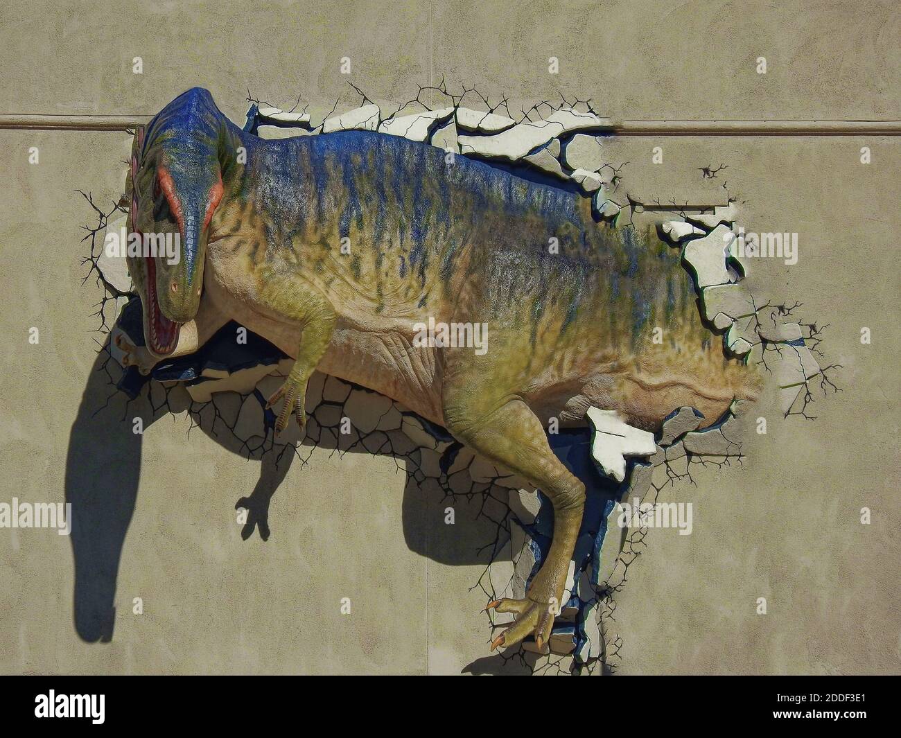 I dinosauri esplodono attraverso il muro di un edificio Foto Stock