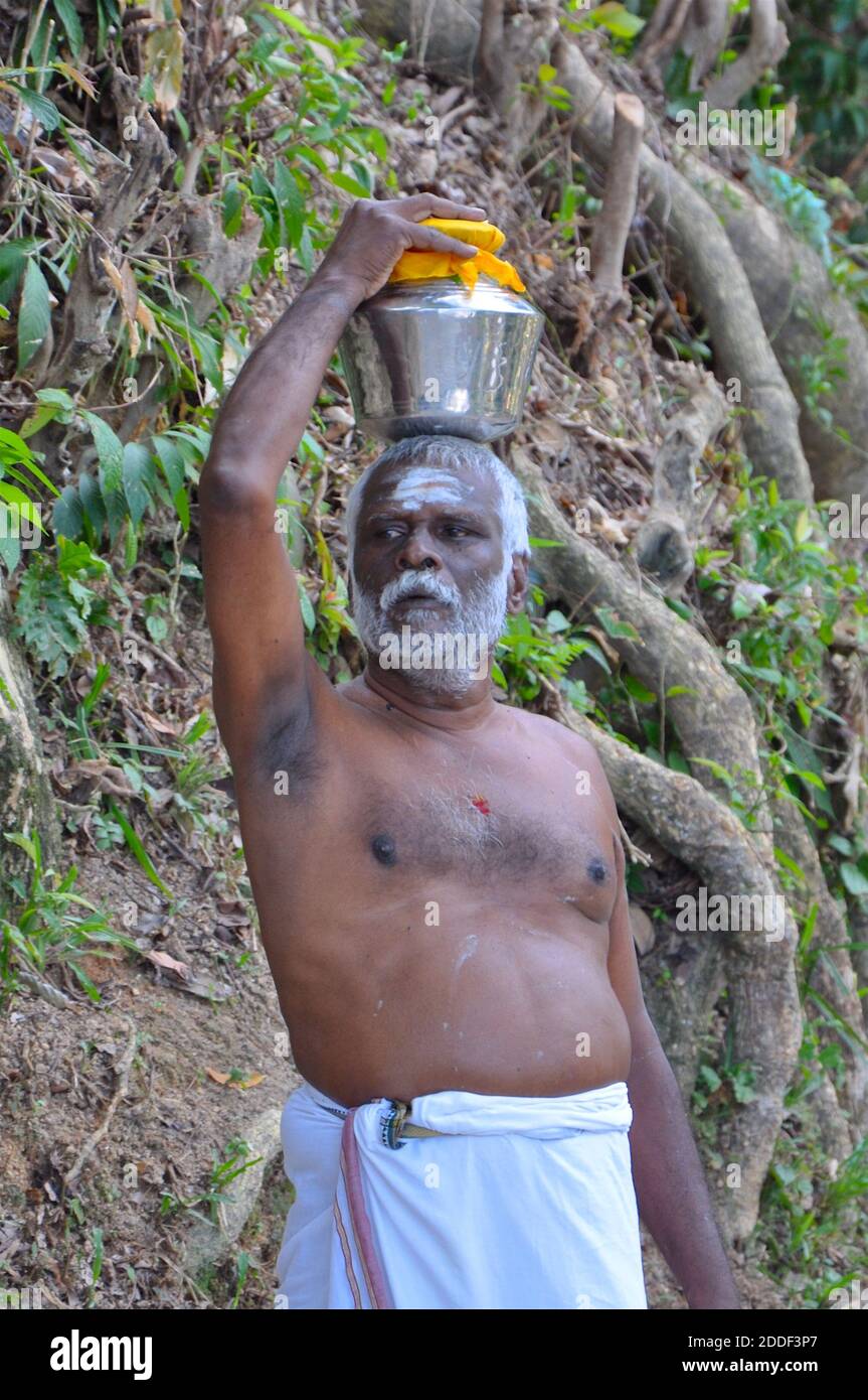 Devoto indù con un'urna di latte come offerta durante le tradizionali celebrazioni thaipusam. Foto Stock