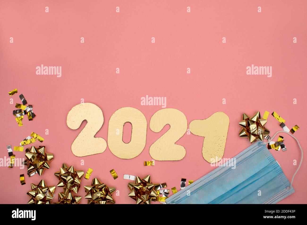Numero 2021 su sfondo rosa decorato con confetti dorati alle stelle. Concetto di festa di Capodanno Foto Stock