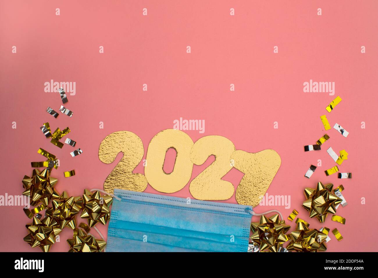 Numero 2021 su sfondo rosa decorato con confetti dorati alle stelle. Concetto di festa di Capodanno Foto Stock