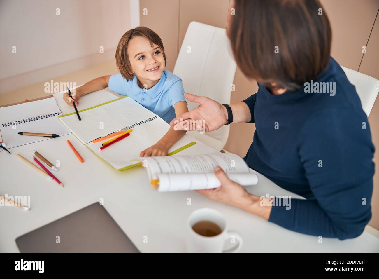 Il mio papà spiega il nuovo argomento nel modo più interessante Foto Stock