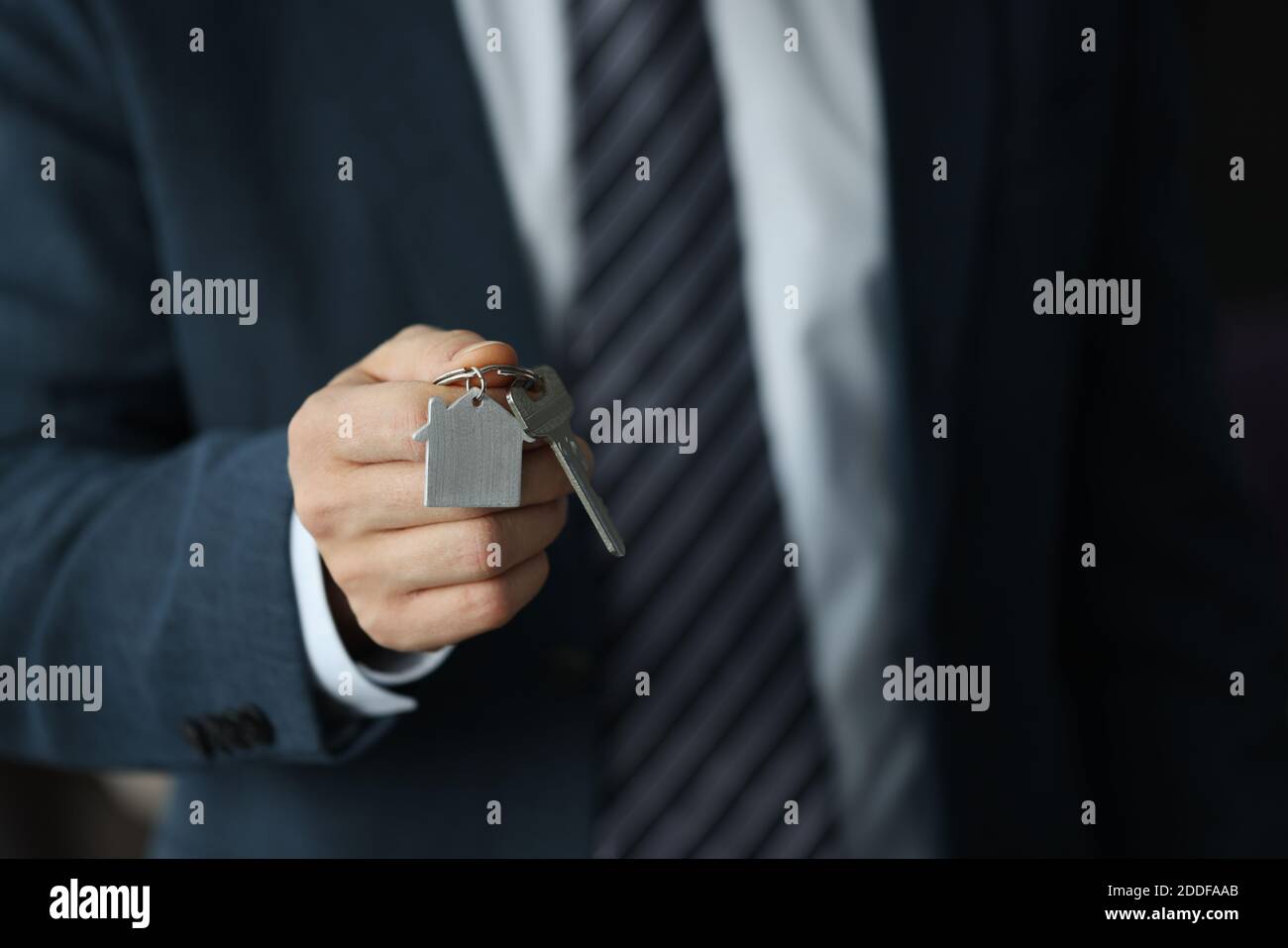 Silhouette di uomo d'affari che tiene le chiavi in mano. Foto Stock