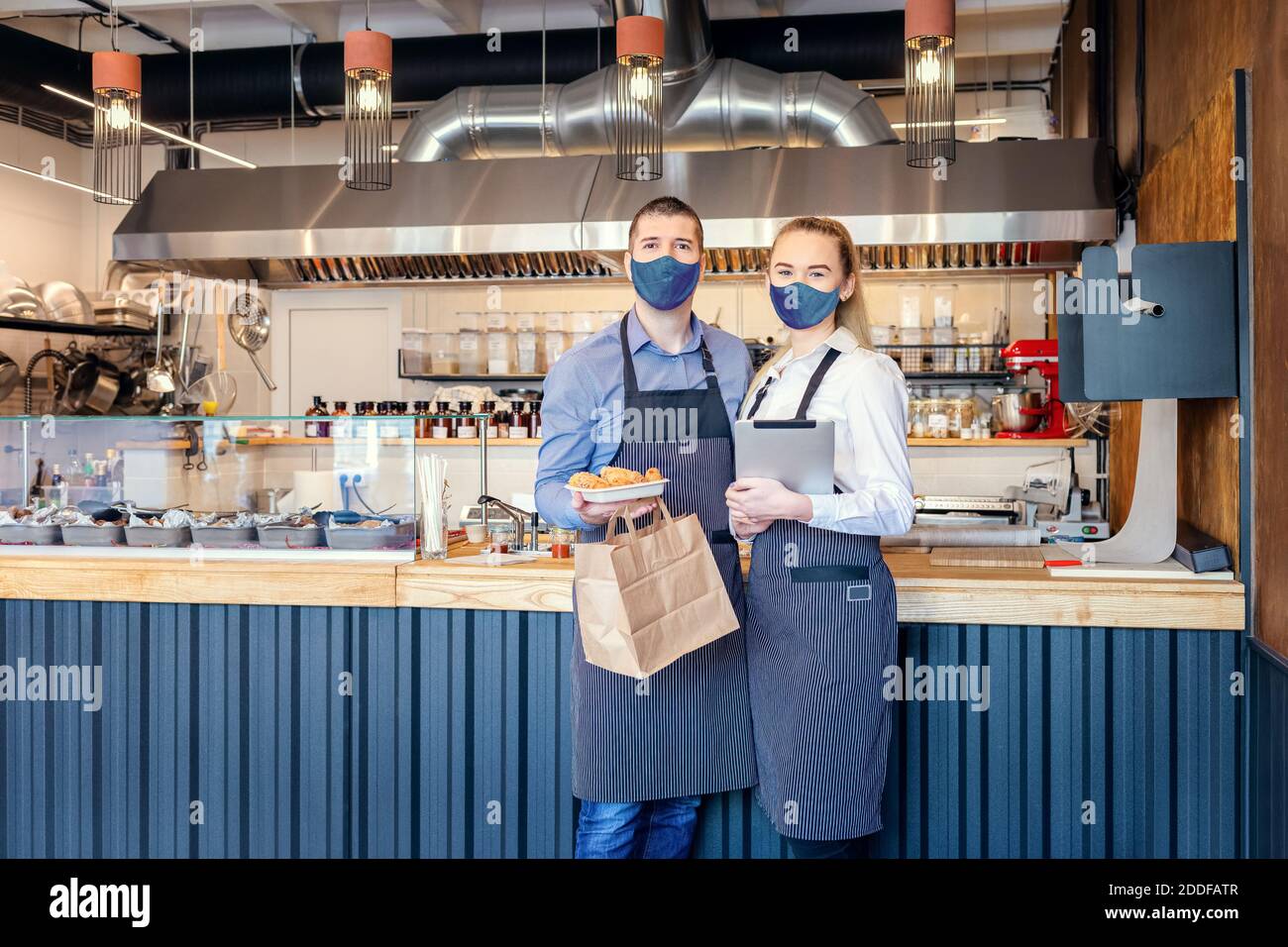 Consegna di cibo e servizio "to go" grazie al covid-19 blocco di emergenza con i proprietari di ristoranti che servono cibo da portare via Foto Stock