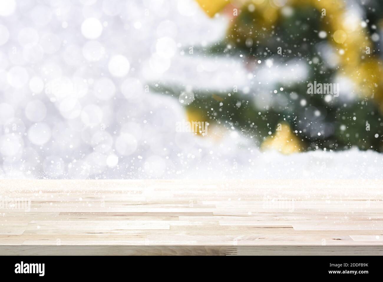 Tavolo in legno su bokeh bianco astratto e sfocare Natale albero sfondo in inverno nevicata - può essere utilizzato per mostra e montatura i tuoi prodotti Foto Stock
