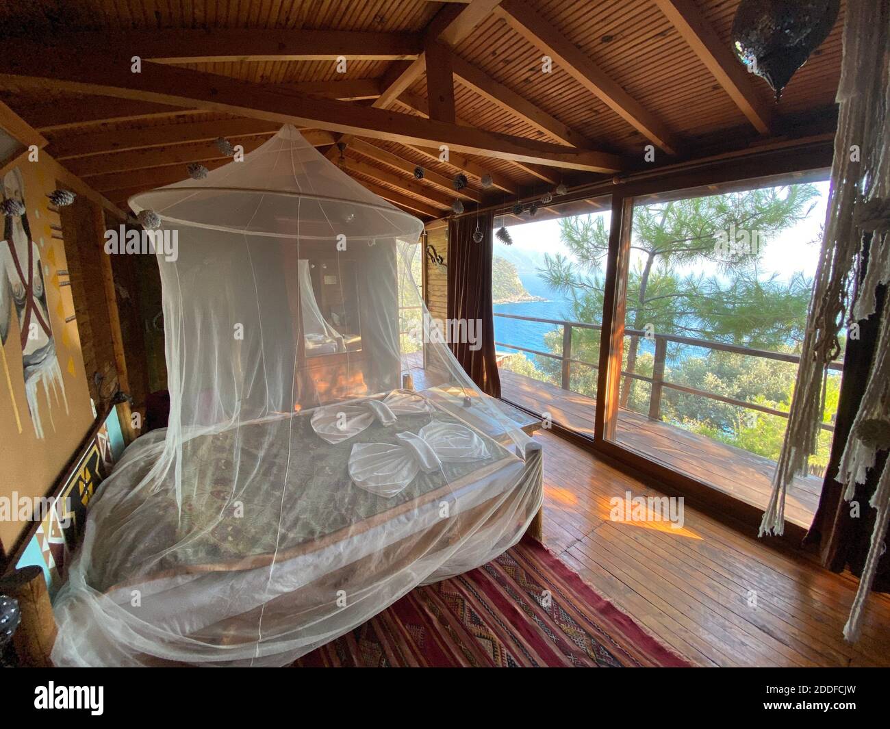 Romantica e tranquilla camera in legno con vista mare e alberi. Costume da luna di miele per vacanze di isolamento e silenzio. Stanza isolata in natura. Foto Stock