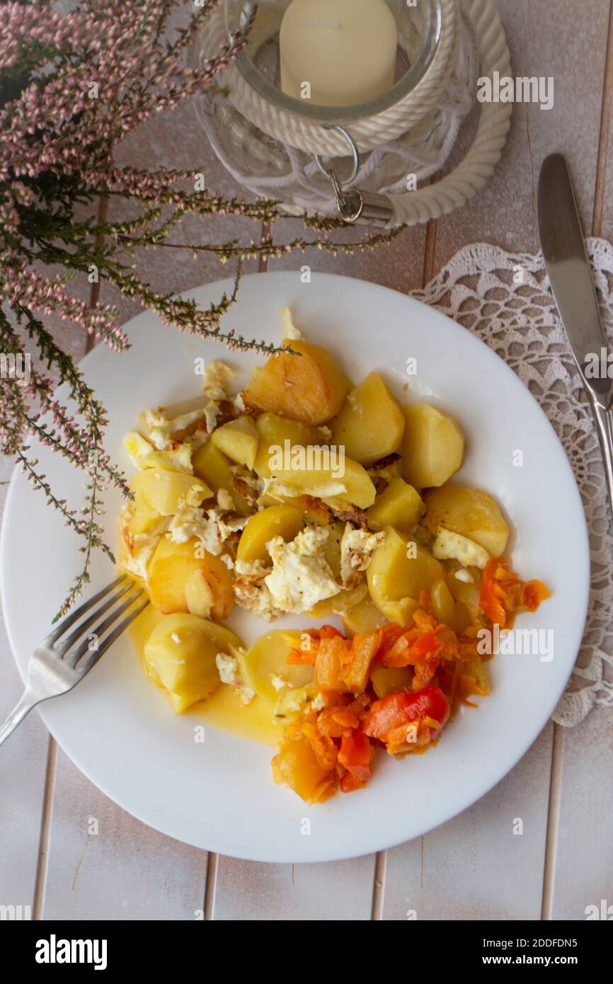 Patate bollite con verdure su piatto bianco. Vista piatta Foto Stock